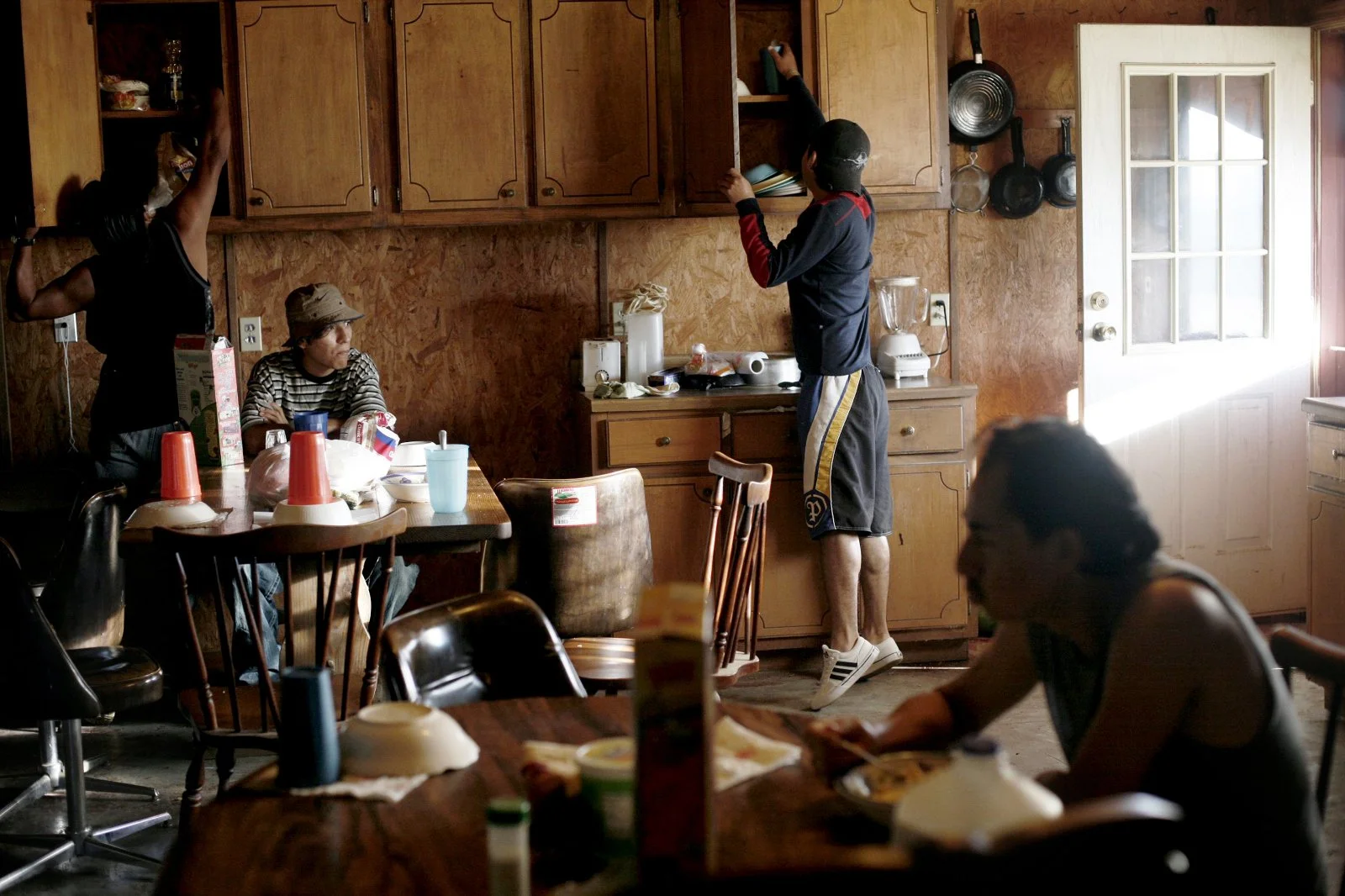Guadalupe watches out the window while Spanish-language television plays during the chaos of morning in the migrant workers house. Guadalupe was the newest worker on Barber farm. He was working on paying off loans for the travel expenses here before 