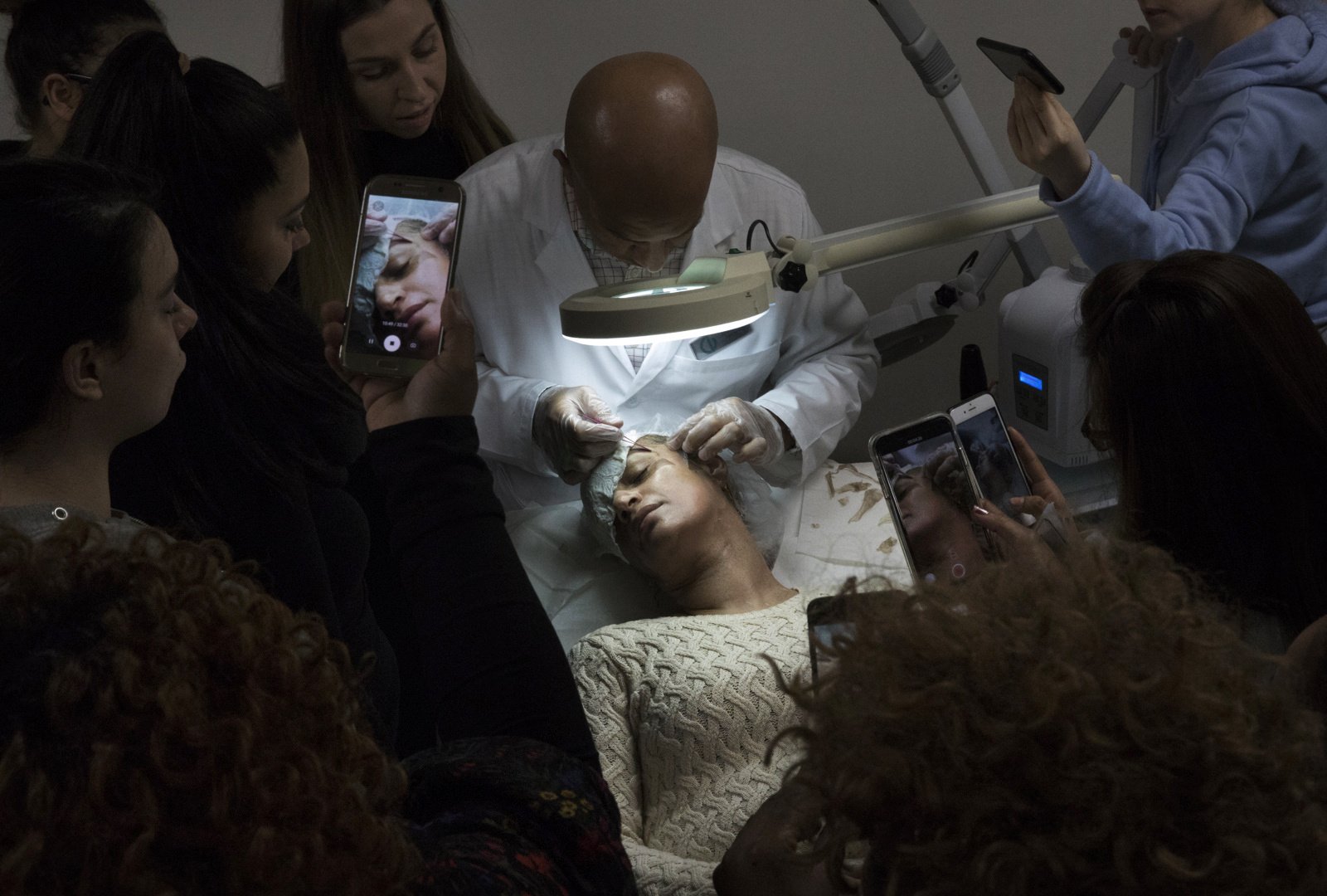 Elias Hernandez, head instructor at Christine Valmy, removes dried skin from a model’s face during a class on chemical peels in New York. Removing the flaked skin is the final stage of the multiple day deep chemical peel.