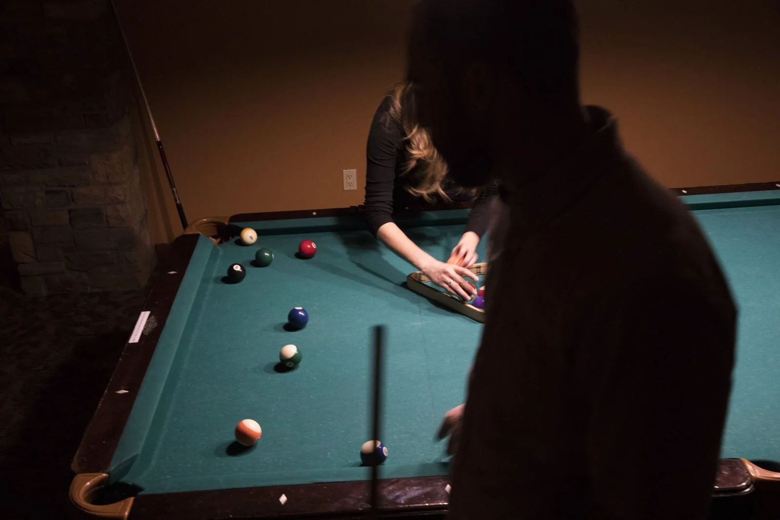 Ilse Carolina racks up billiard balls for a game of pool in Eagle, Colo.