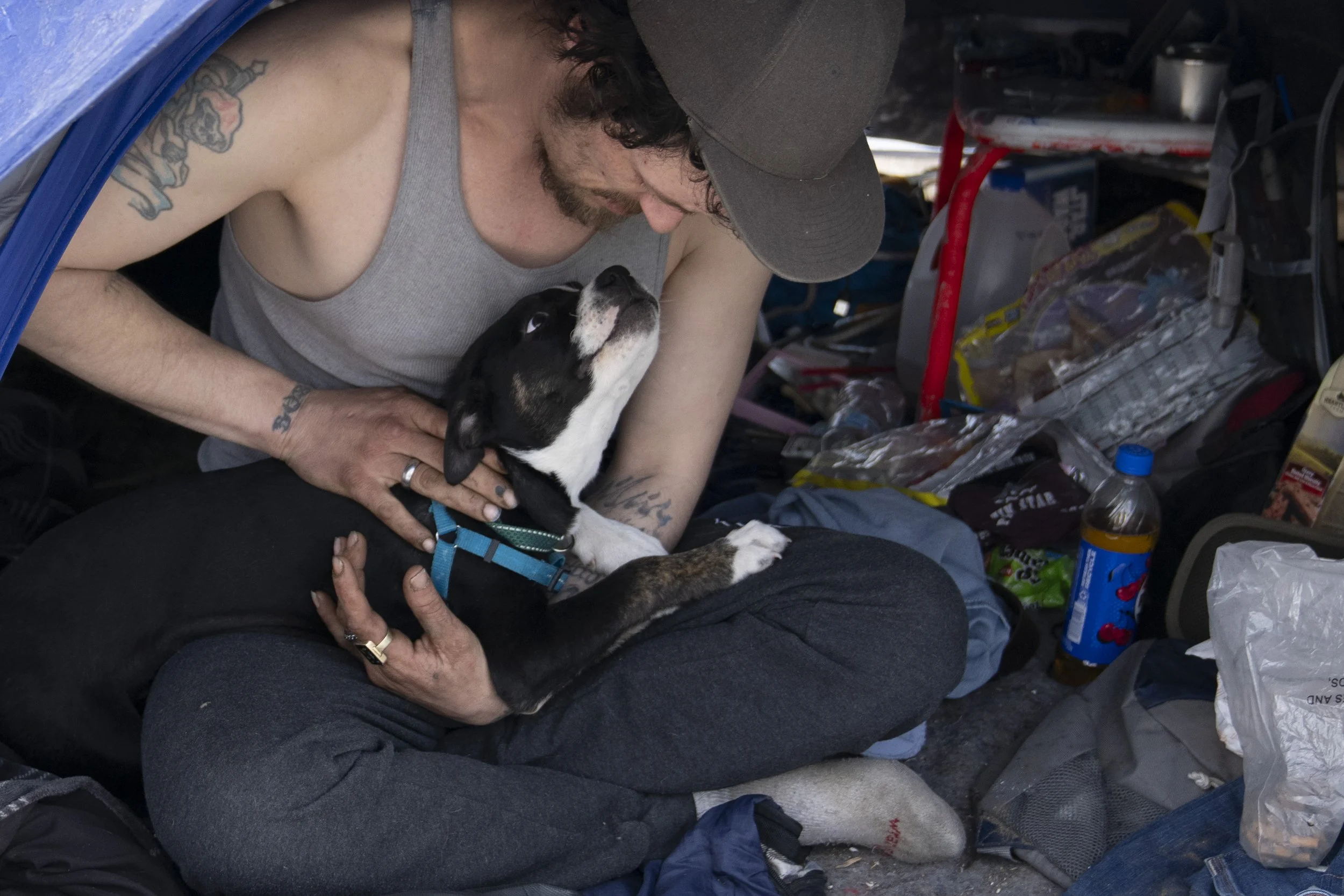 Kevin Reeves looks at his puppy while in his tent in Baker Park on Thursday, March 21, 2024, in Grants Pass, Ore.