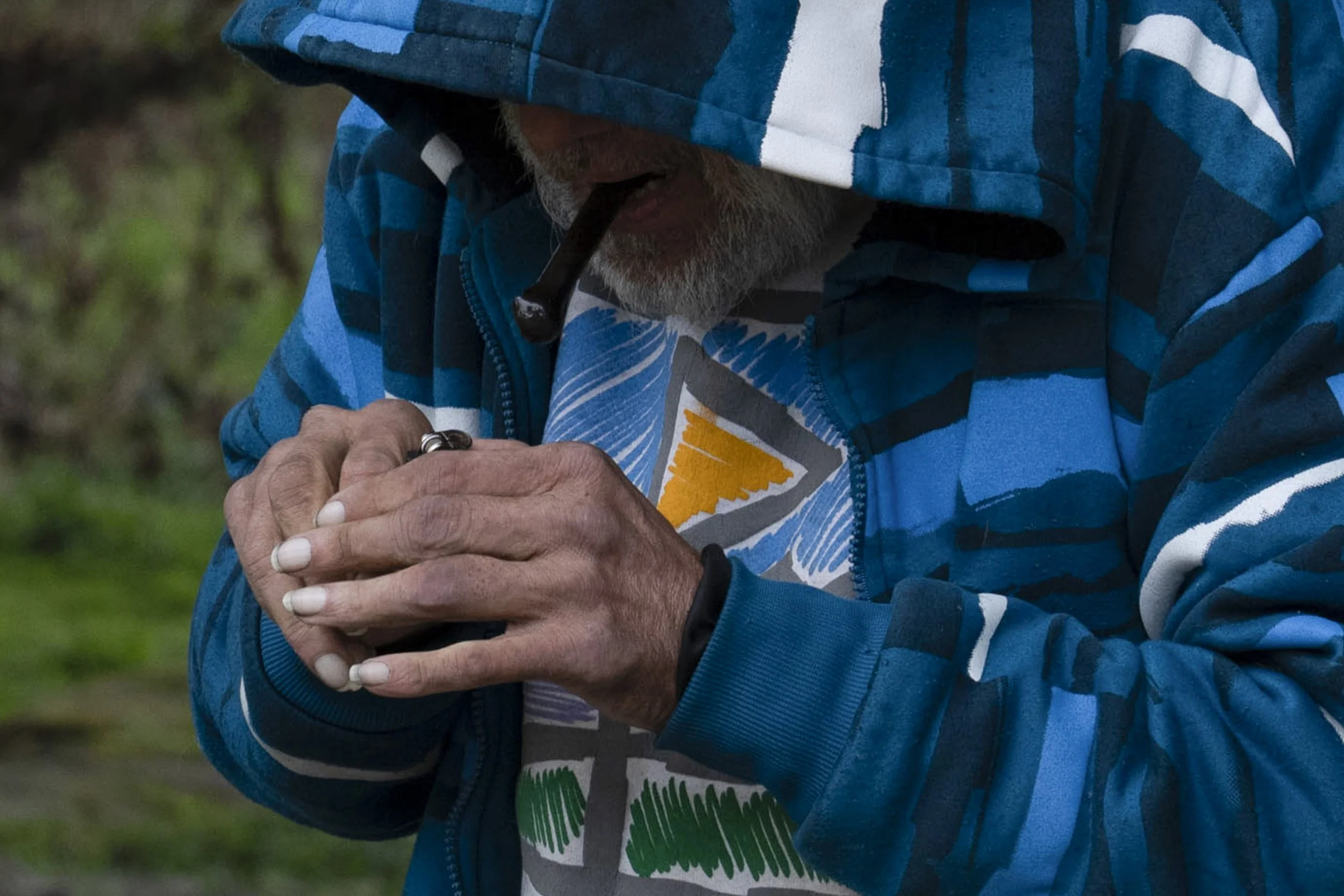 A homeless person tries to use a lighter to smoke drugs on Friday, March 22, 2024, in Grants Pass, Ore.