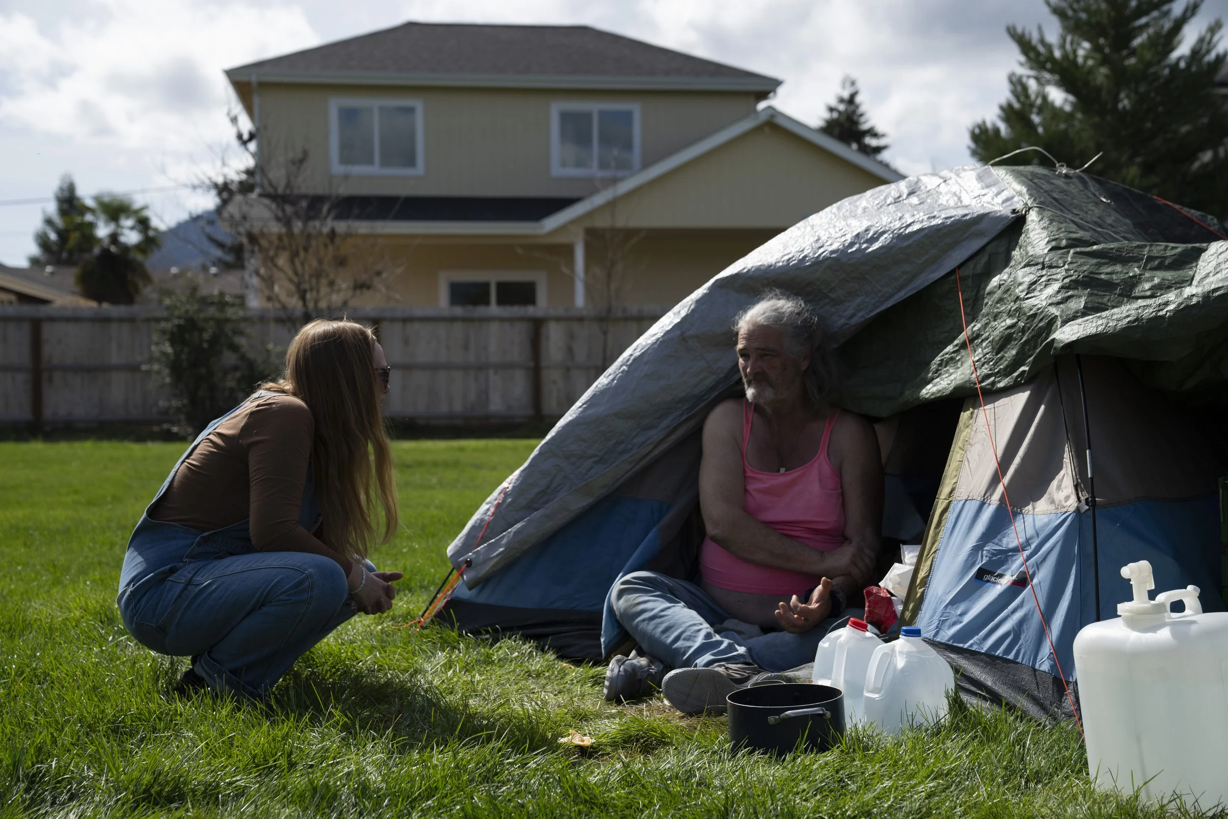 Cassy Leach, a nurse who leads a group of volunteers providing food, medical care, and other basic goods to hundreds of homeless people living in the parks, talks to a homeless person on Thursday, March 21, 2024, in Grants Pass, Ore. 