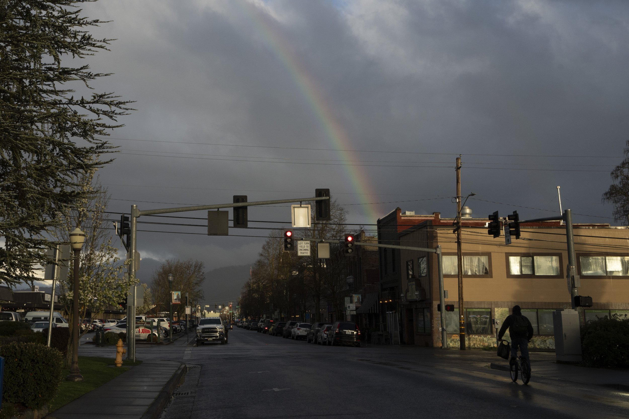 A rainbow appears over the downtown area of Grants Pass, Friday, March 22, 2024.