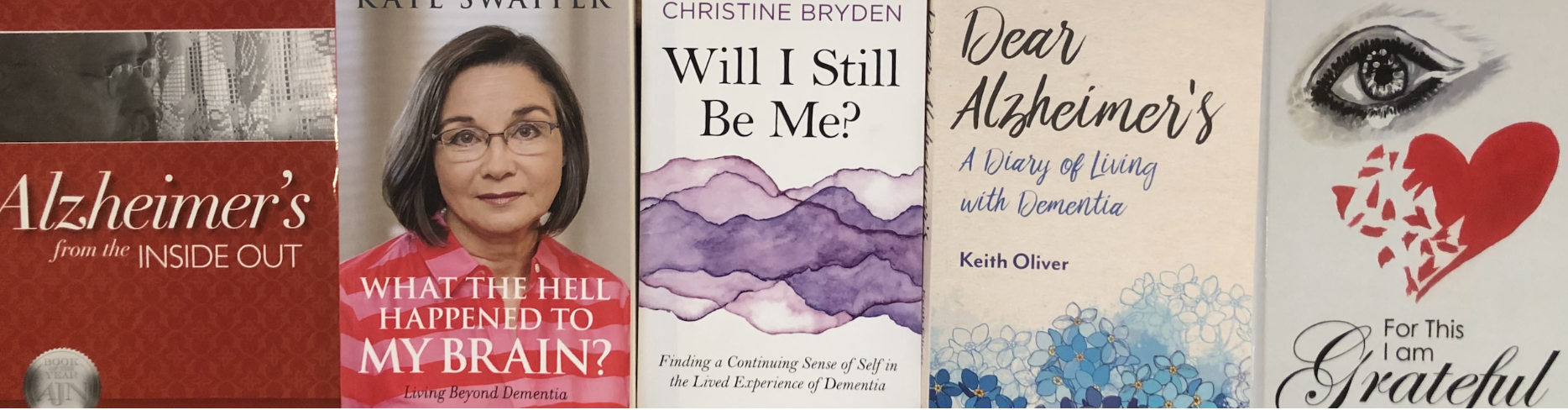 Collection of five books about Alzheimer's disease, dementia, and personal experiences with these conditions. The covers feature titles, author names, and various artwork including a woman's portrait, abstract purple mountains, flowers, an eye, and a broken heart with a gratitude message.