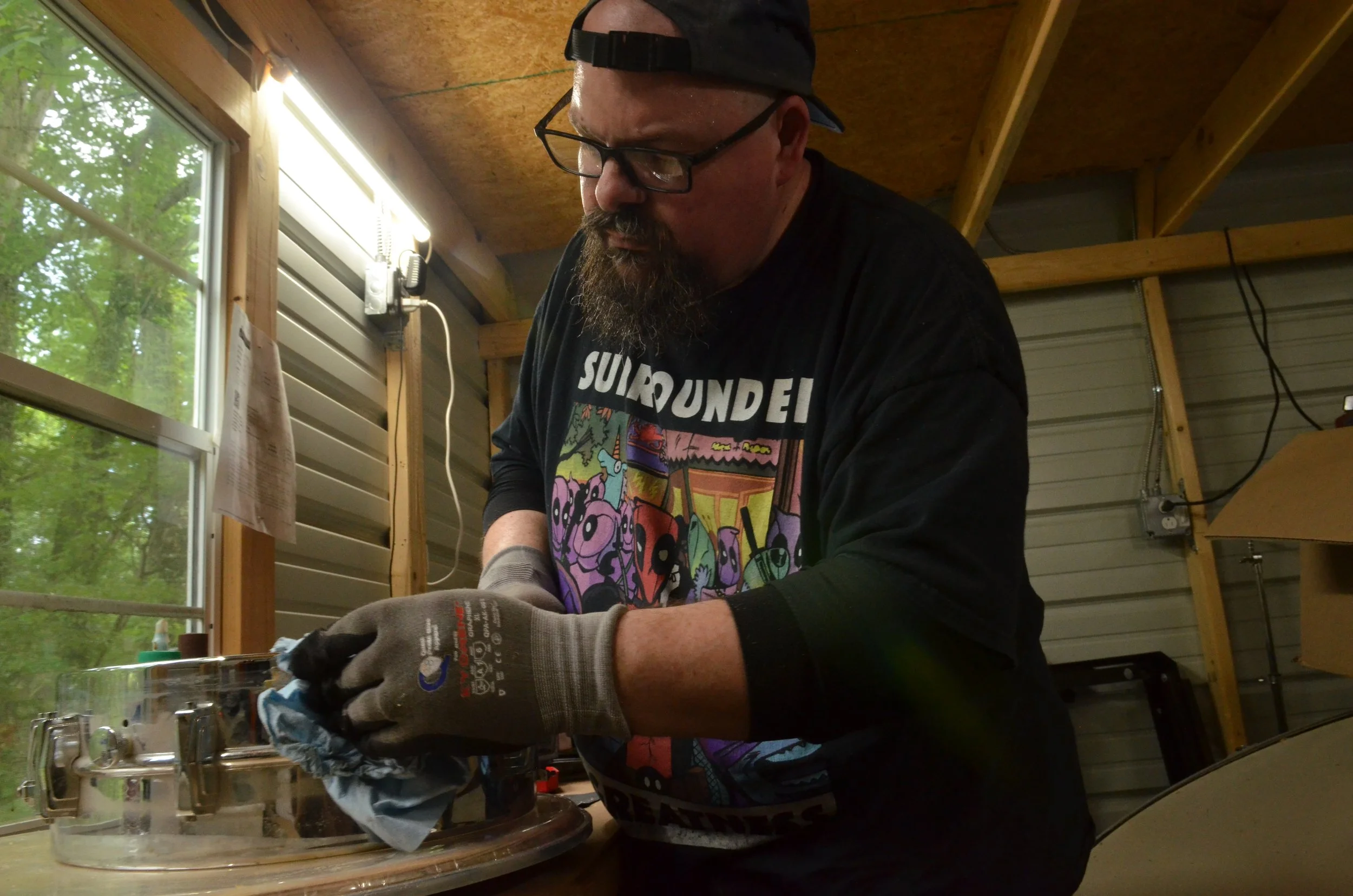 Don polishes a snare drum shell.