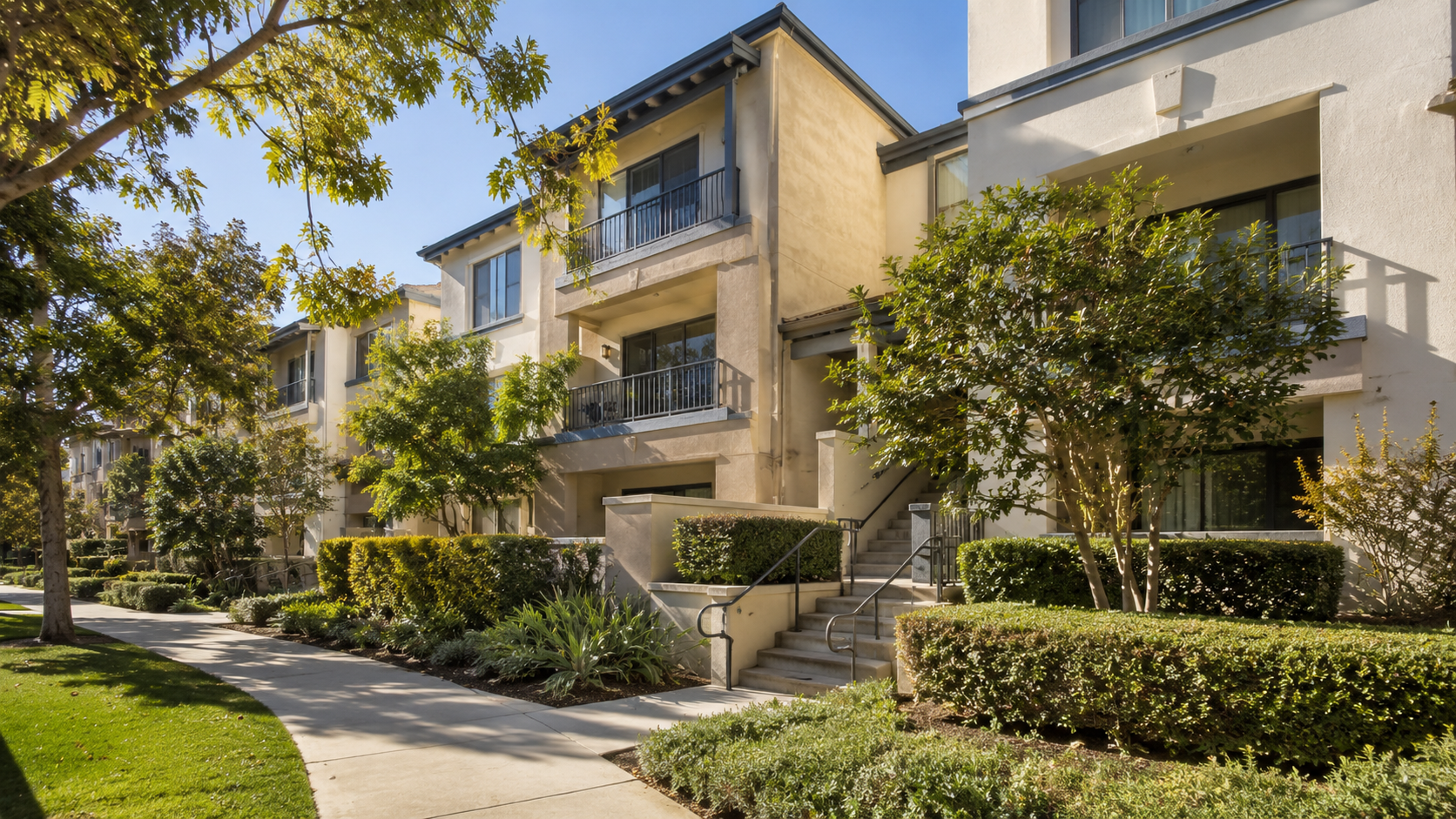 Landscaped condominium community with balconies and exterior stairways