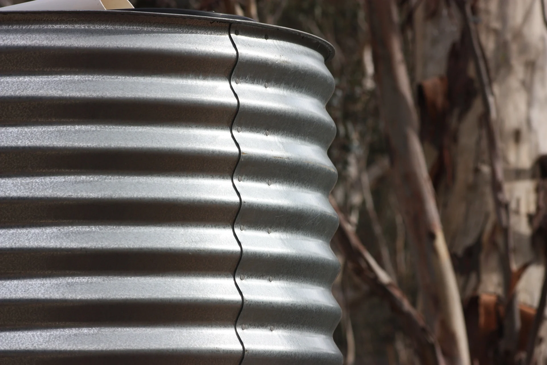 Close-up of a silver, corrugated metal surface with a wavy edge, likely a stack of metal sheets or cans.