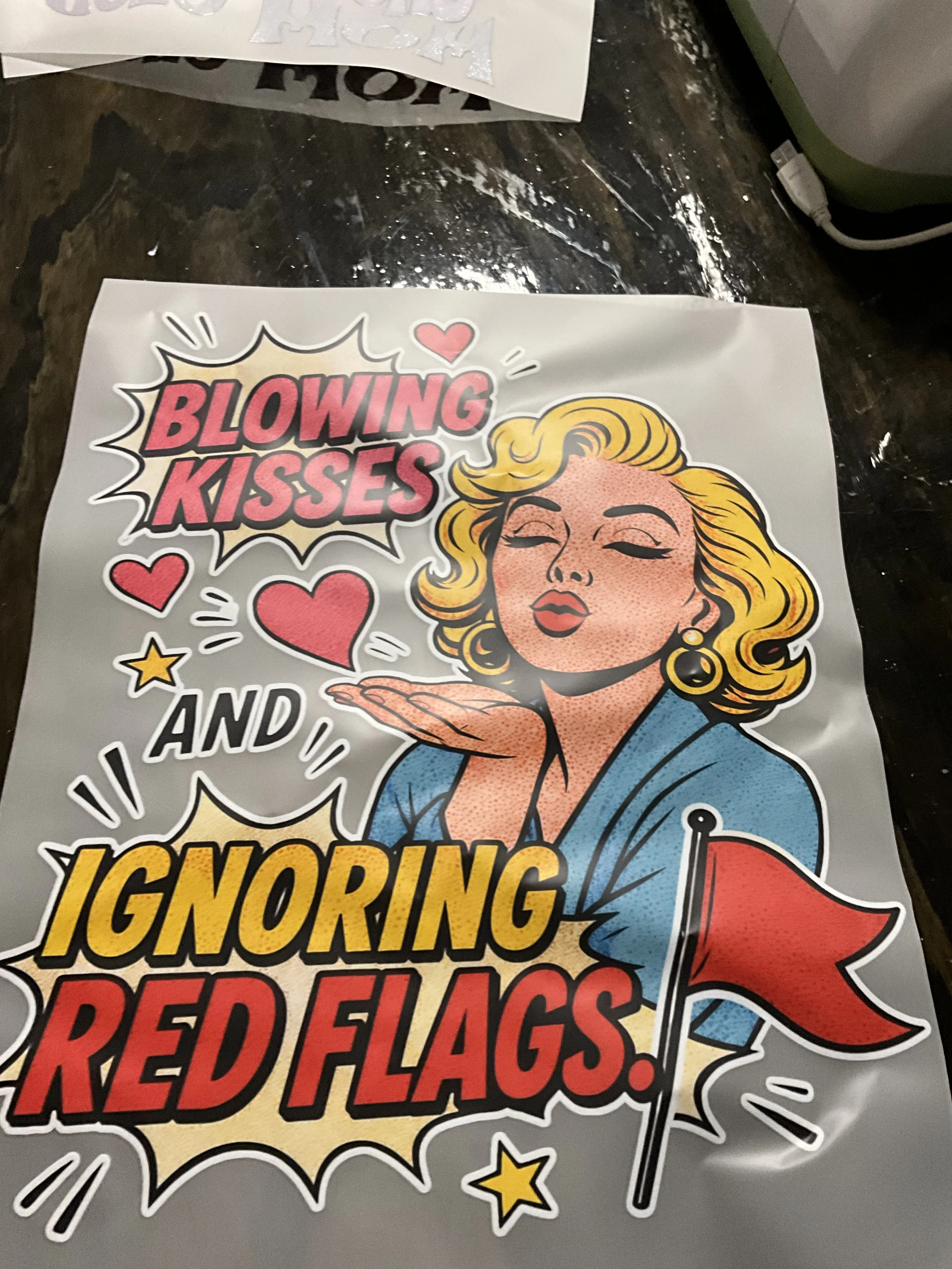 Pop art-style sticker with a woman blowing a red kiss, various hearts and stars, and text that reads 'Blowing kisses and ignoring red flags' in bold, colorful letters.
