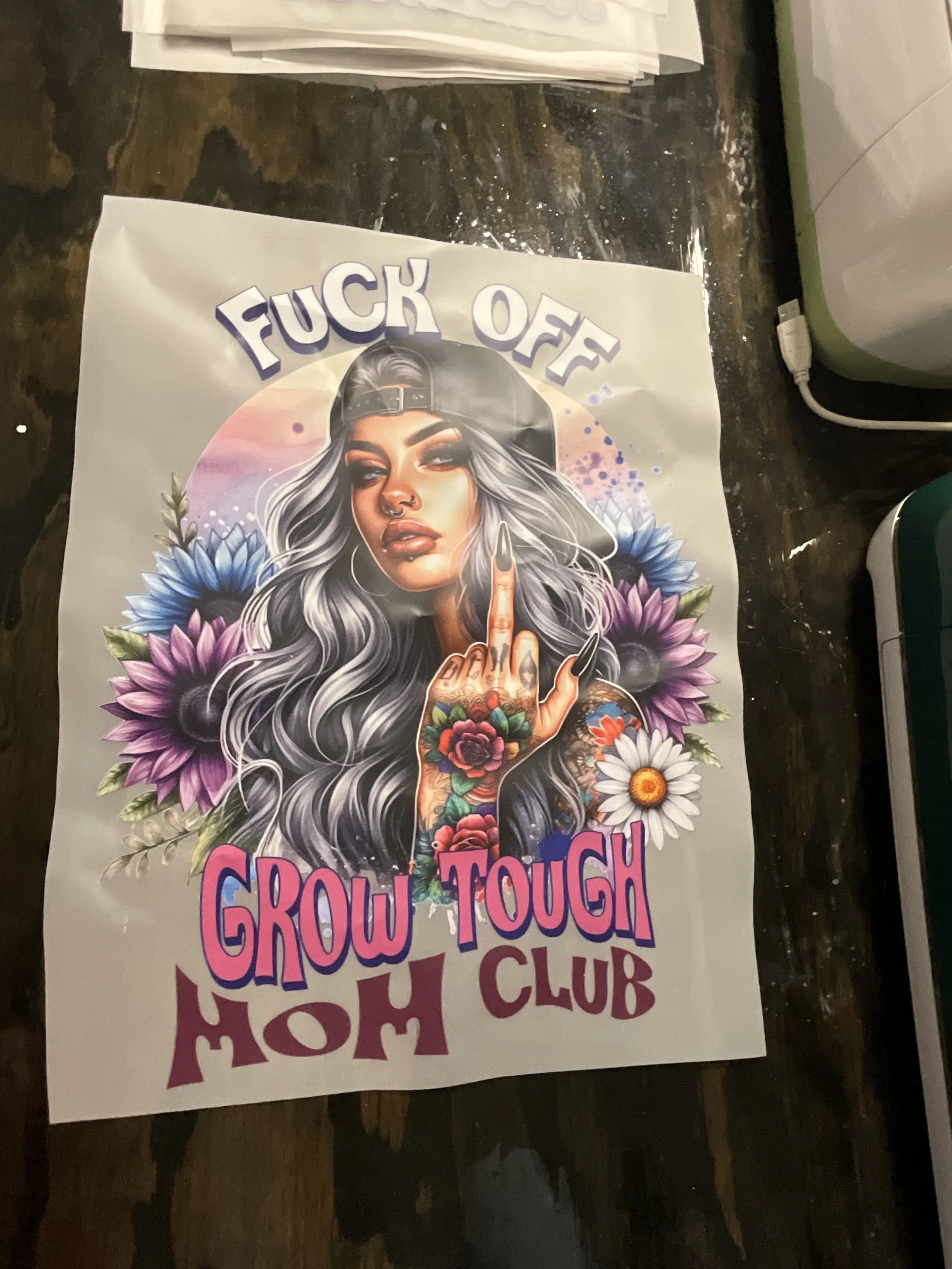 Poster featuring a woman with gray hair and tattoos, surrounded by flowers, with the phrase 'FUCK OFF!' at the top and 'GROW TOUGH' in large colorful letters at the bottom.
