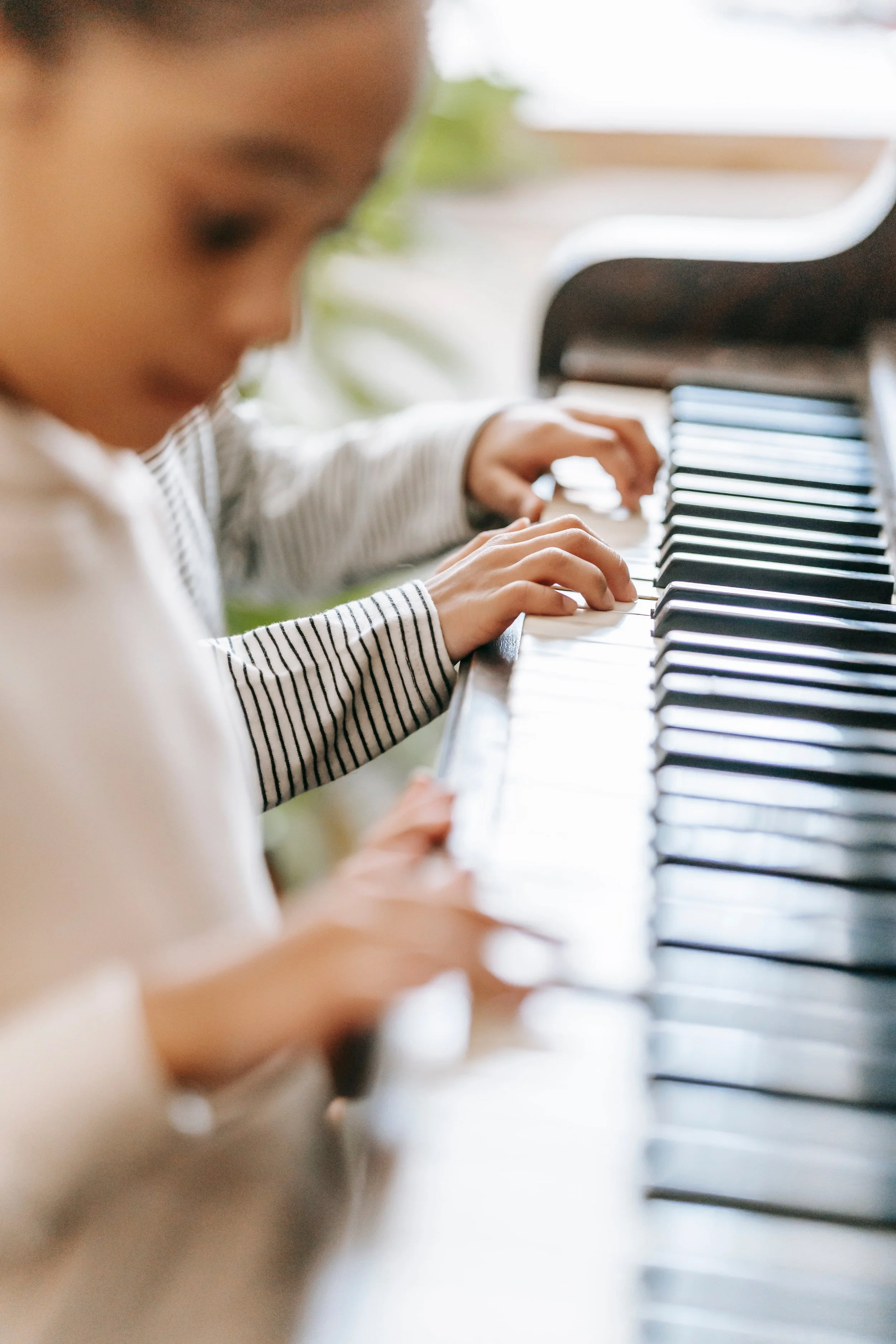 Image of two people (one child) playing the piano