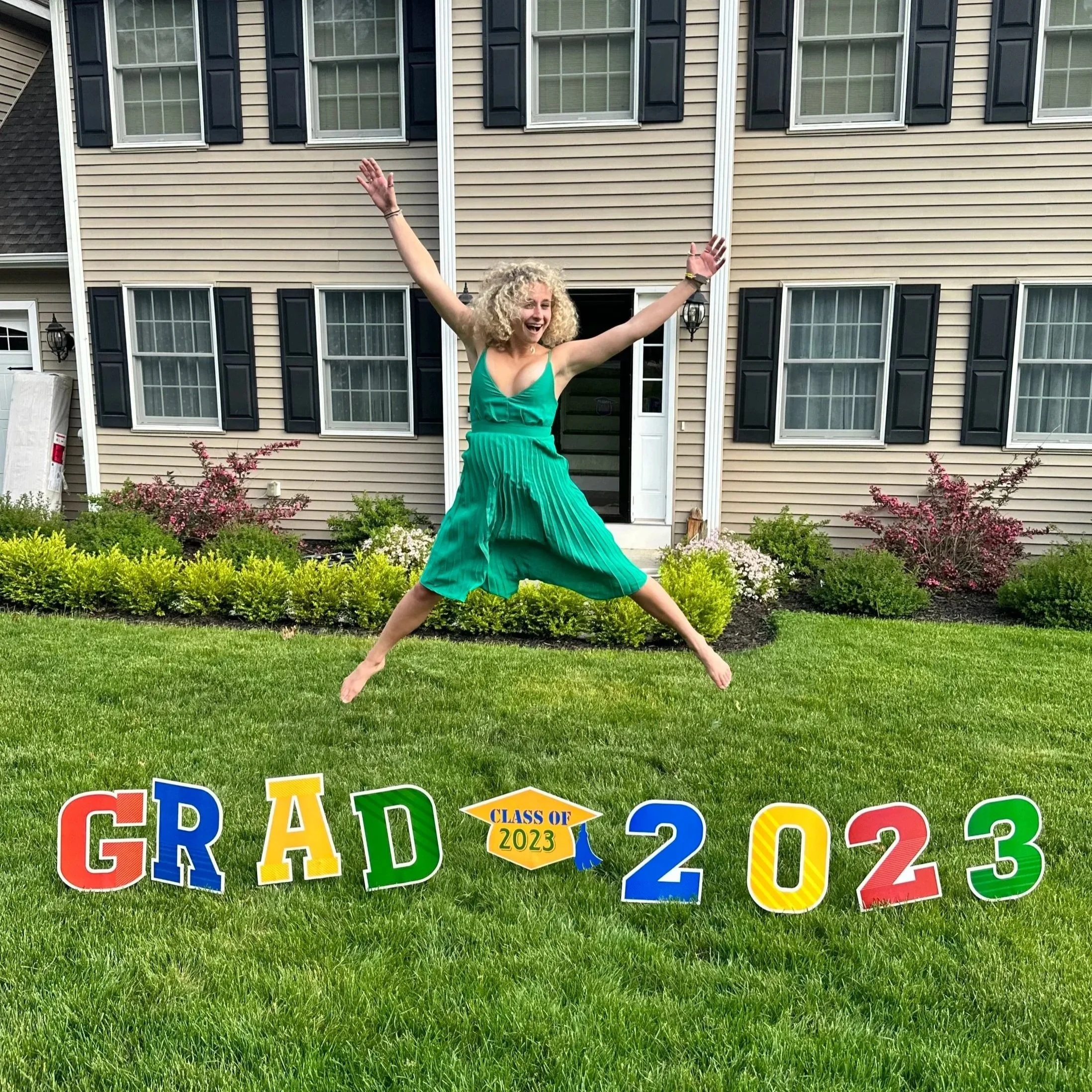 Image of Ciara Gunning jumping in front of a graduation sign