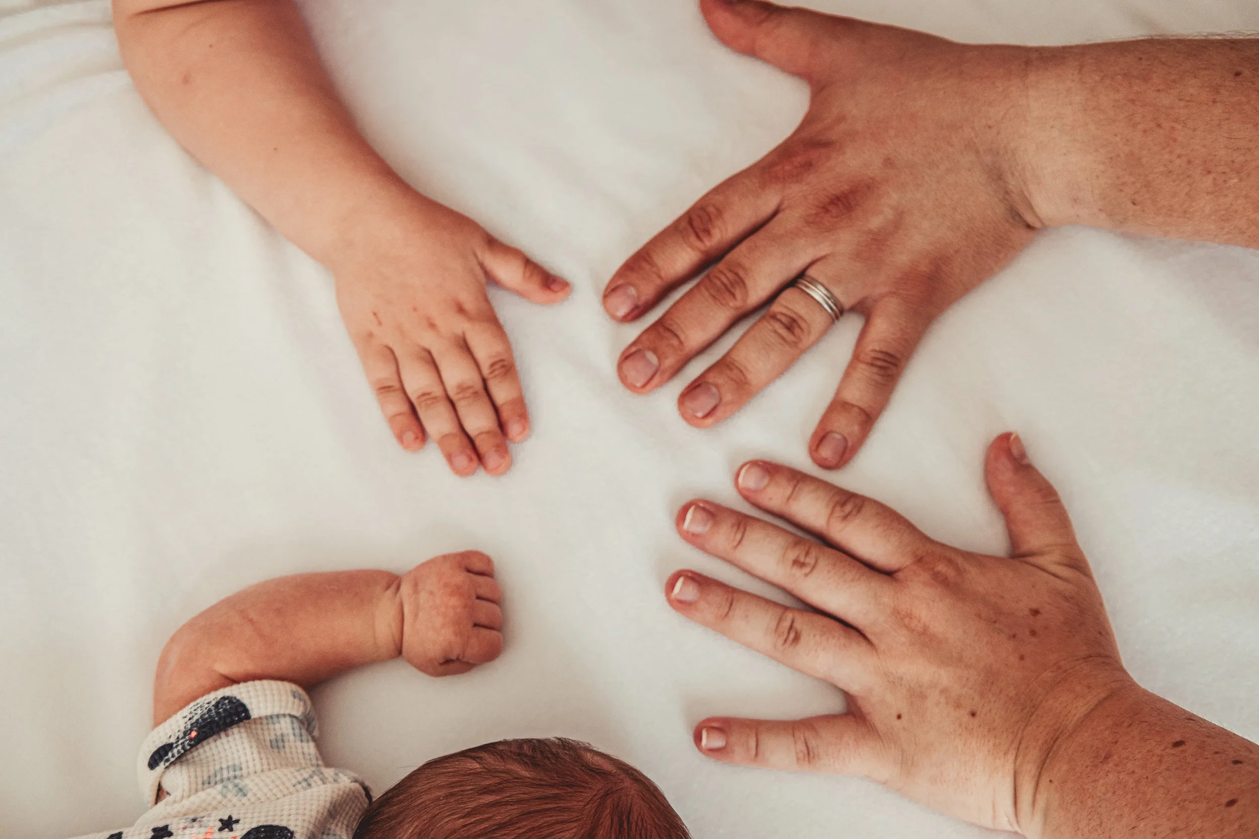 Différentes mains et bras d'âges variés posés sur une surface blanche, symbolisant la diversité et la solidarité intergénérationnelle.