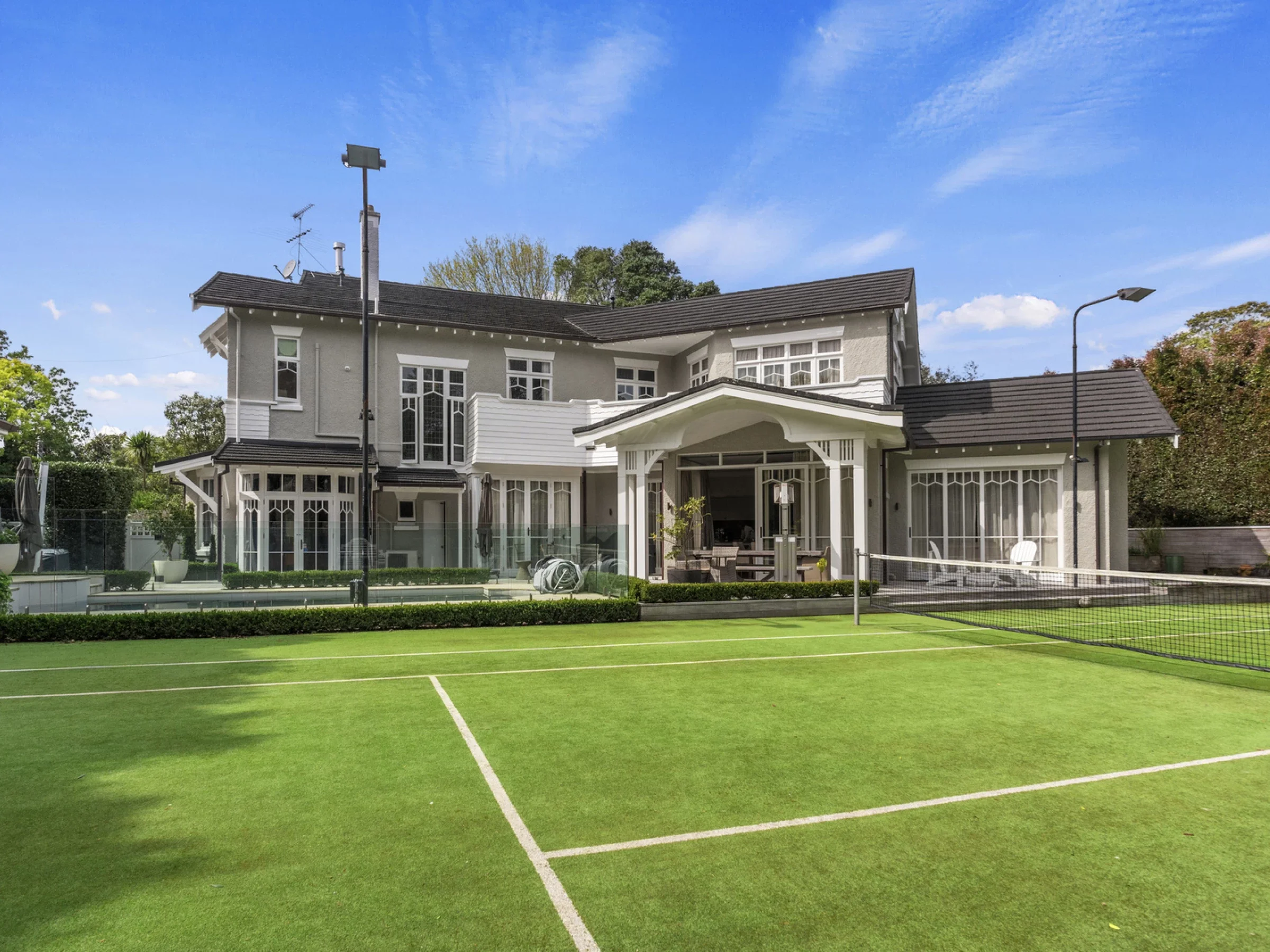 A residential house with a backyard tennis court.