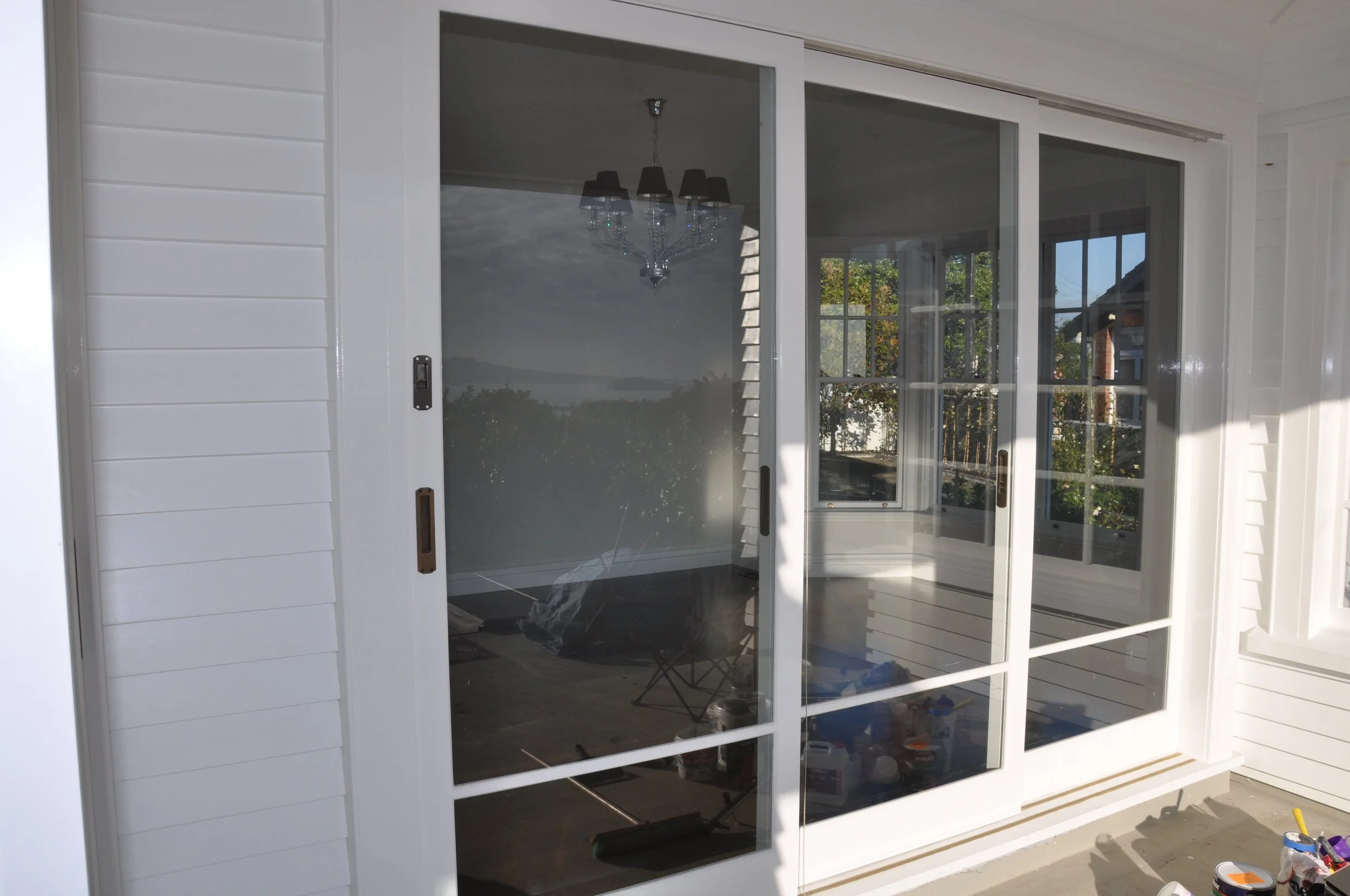White sliding glass door leading to a porch or patio area with white siding on the exterior.