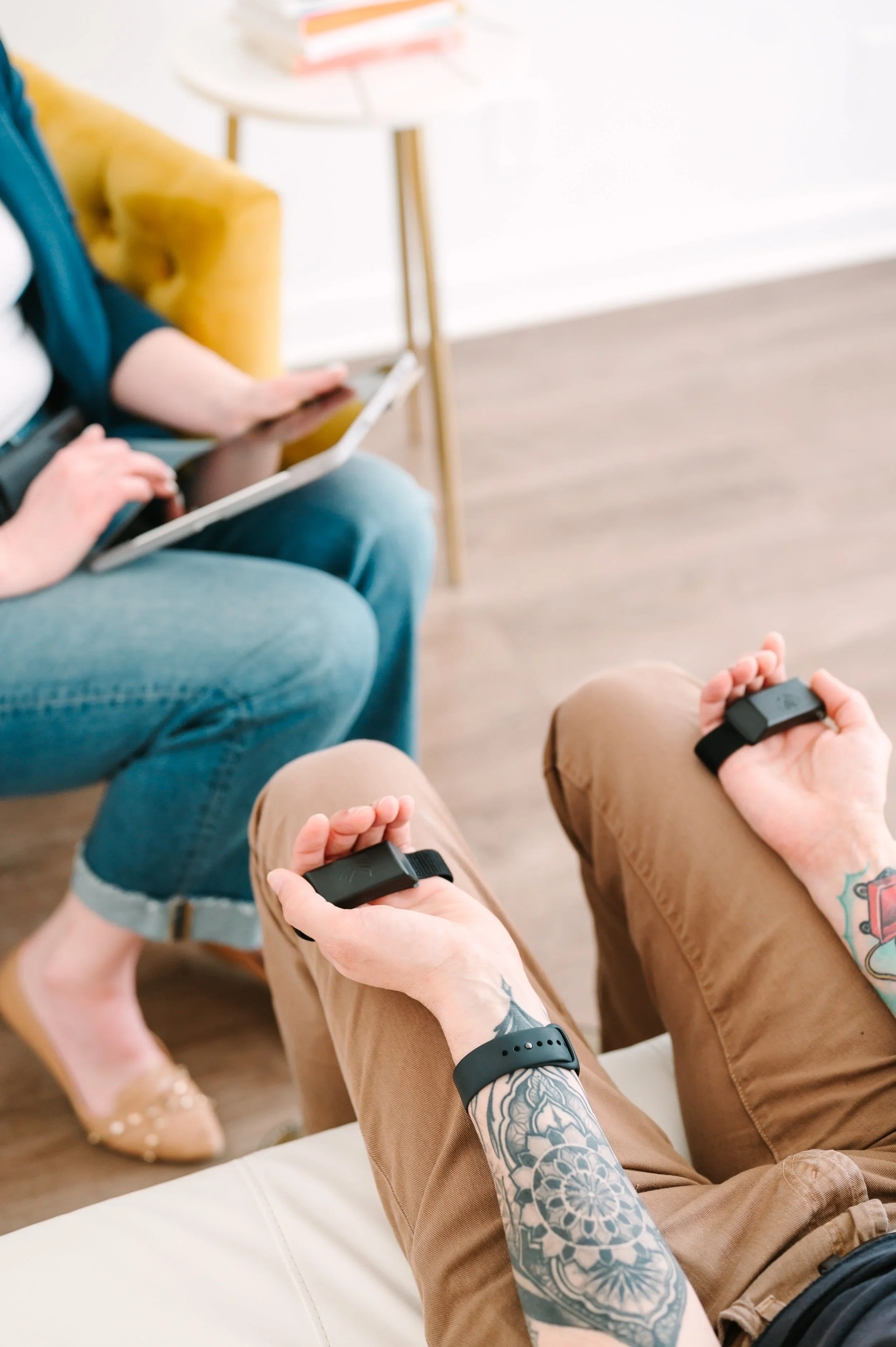 Client holding handheld tappers during an EMDR session.