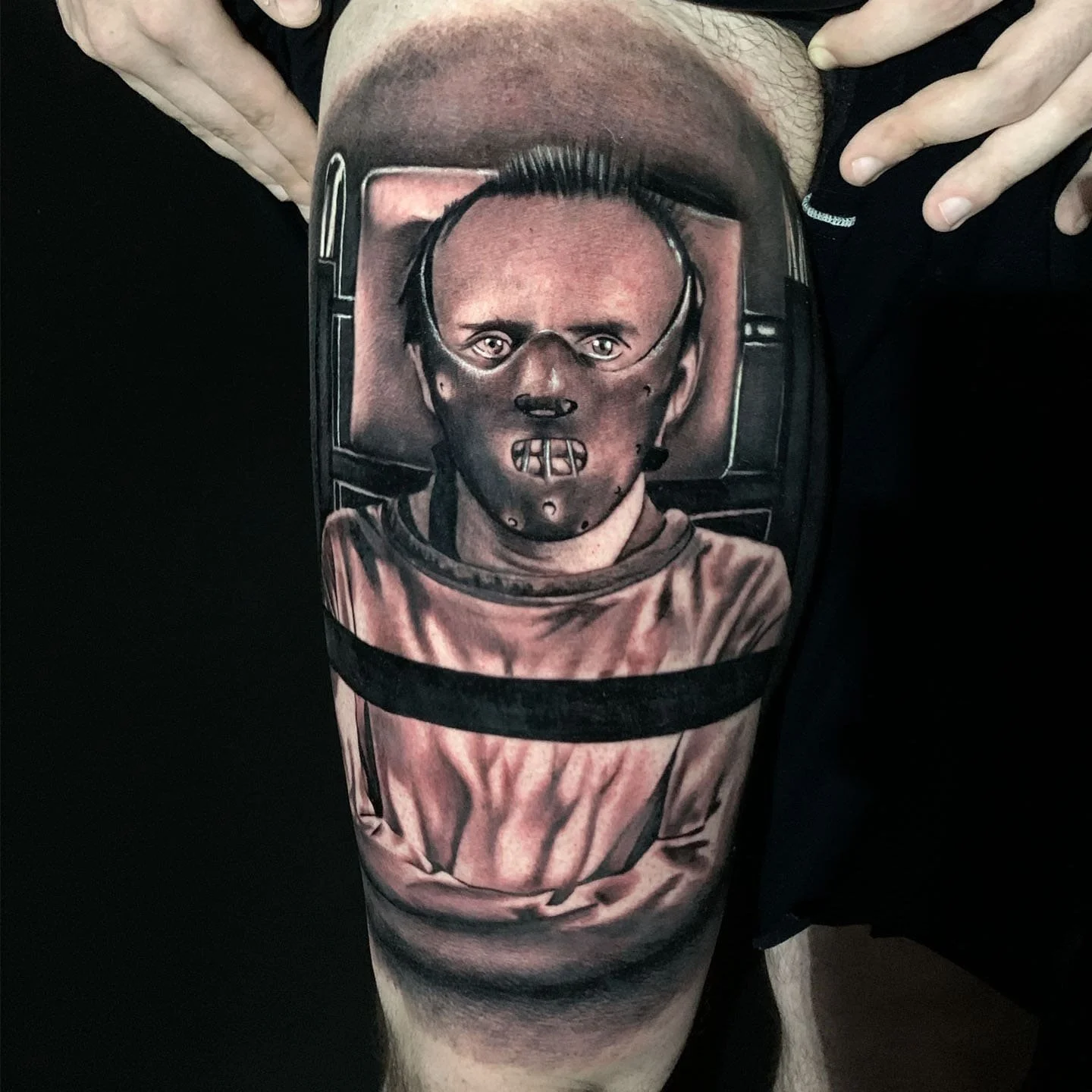 Tattoo of an astronaut's face with a helmet, covering a person's leg
