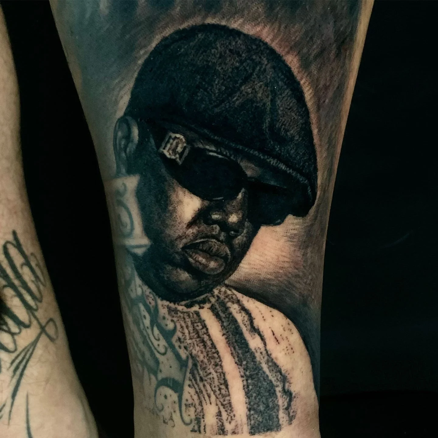 Tattoo of a woman wearing large sunglasses and a headscarf on a person's arm.