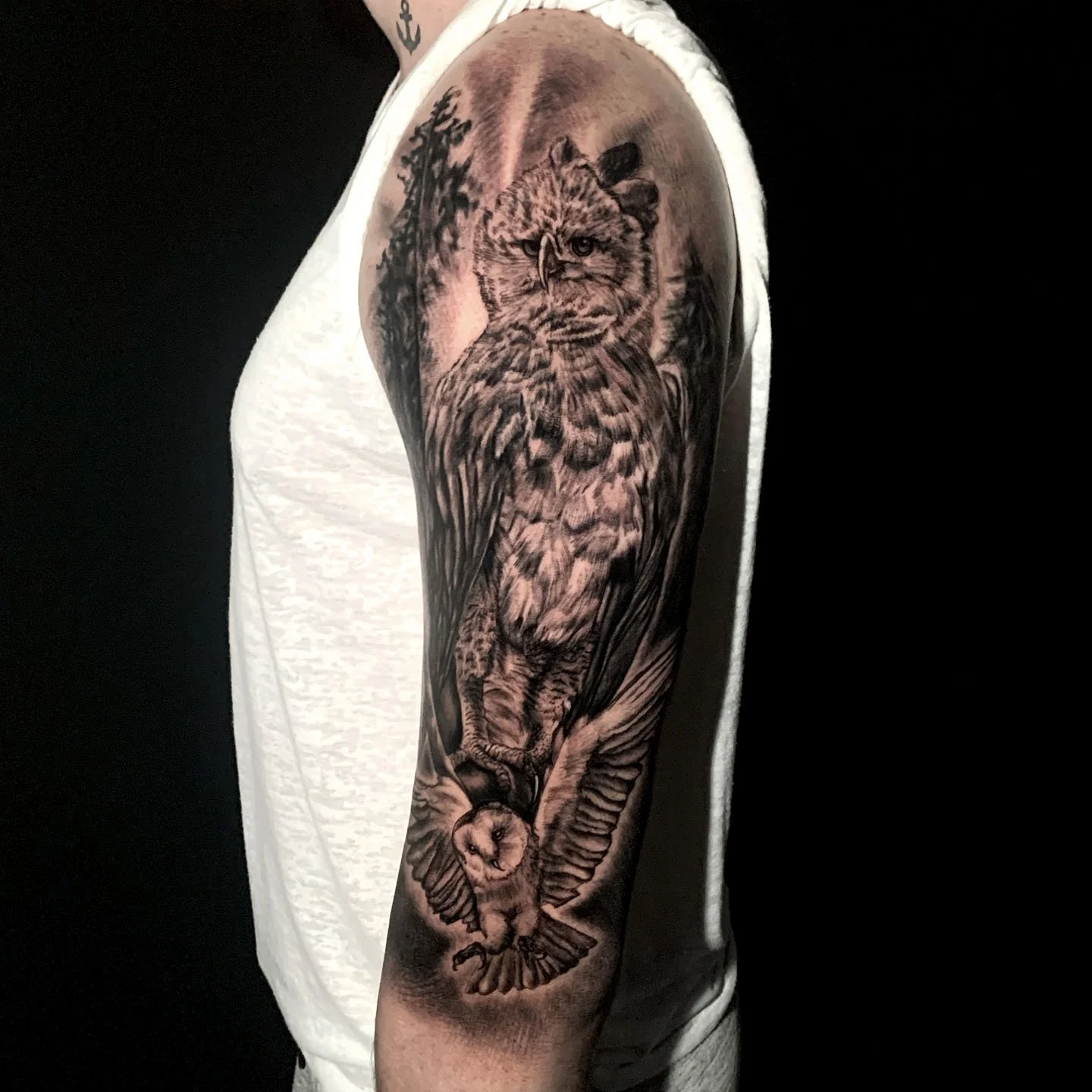 Black and gray tattoo of a wolf on a person's upper arm, with detailed shading and realistic style.
