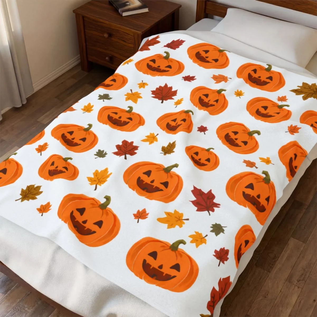 velvet plush blanket with a white background. Red, green, burgandy leaves with happy orange pumpkins thoughout