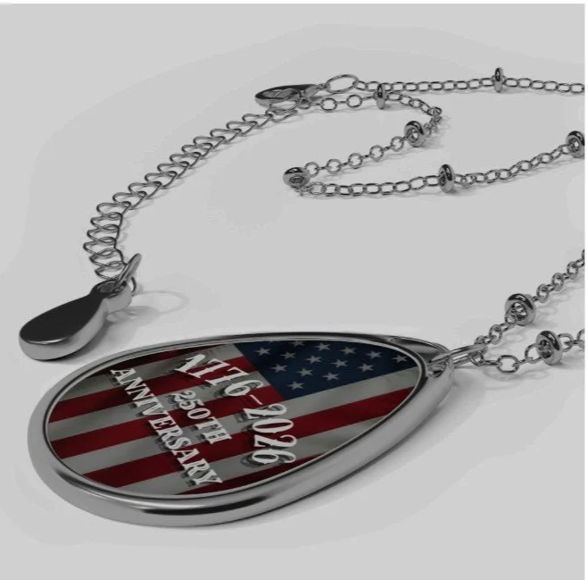 A silver pendant necklace with an American flag design, engraved with the dates 9-11-2001 and 5-25-16, along with the words 'Never Forget' and 'Thank You Mama'.