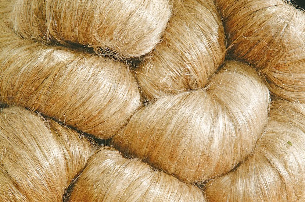 Close-up of several blonde hair wigs stacked together.