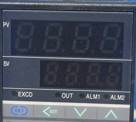 Pantalla de un controlador con showing los valores PV y SV y botones de control.