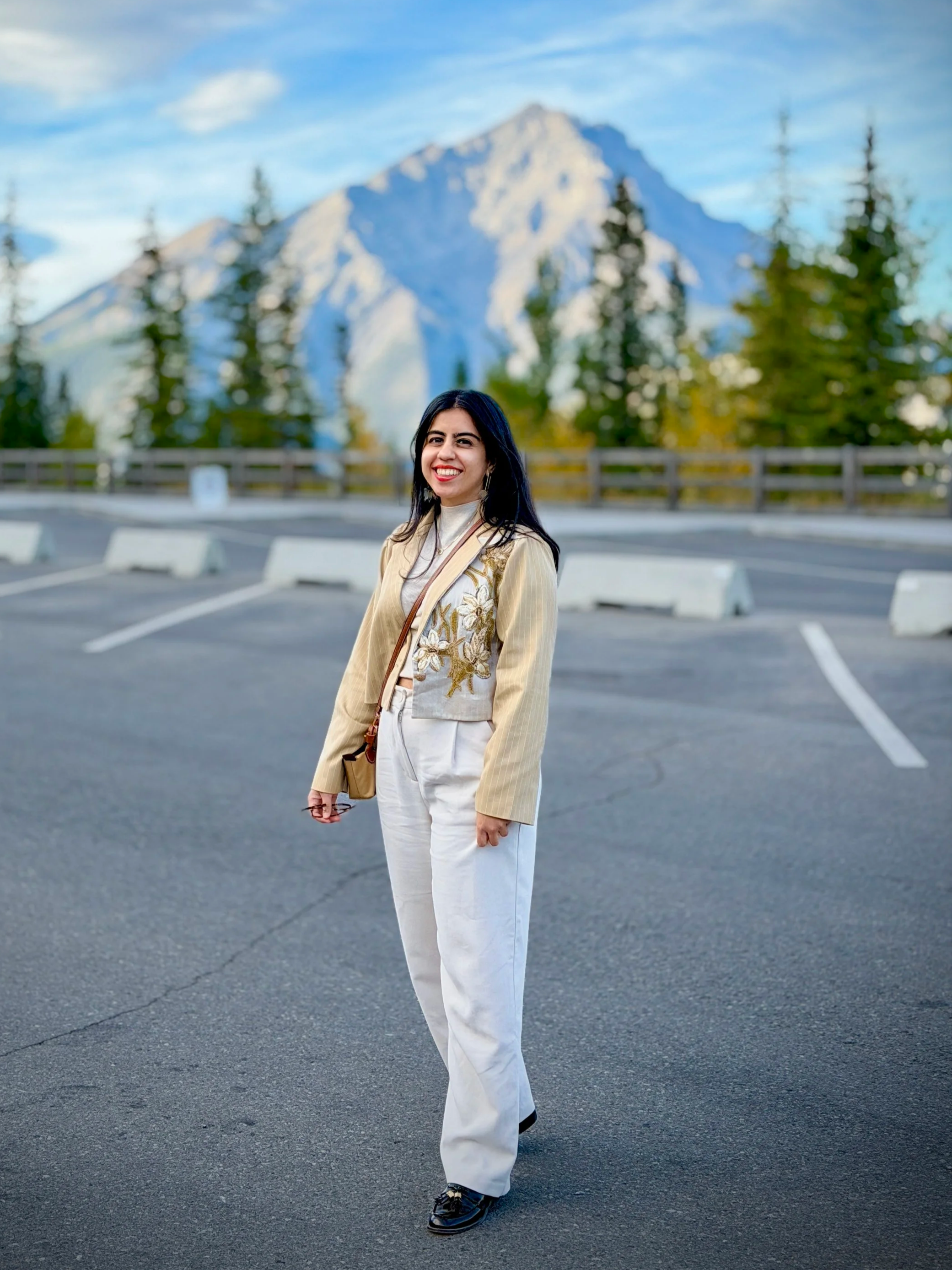 Sanam Panjwani, a wellness coach from Mumbai now based in Toronto, standing grounded against a mountain backdrop, illustrating somatic movement and nervous system regulation tools for corporate professionals.