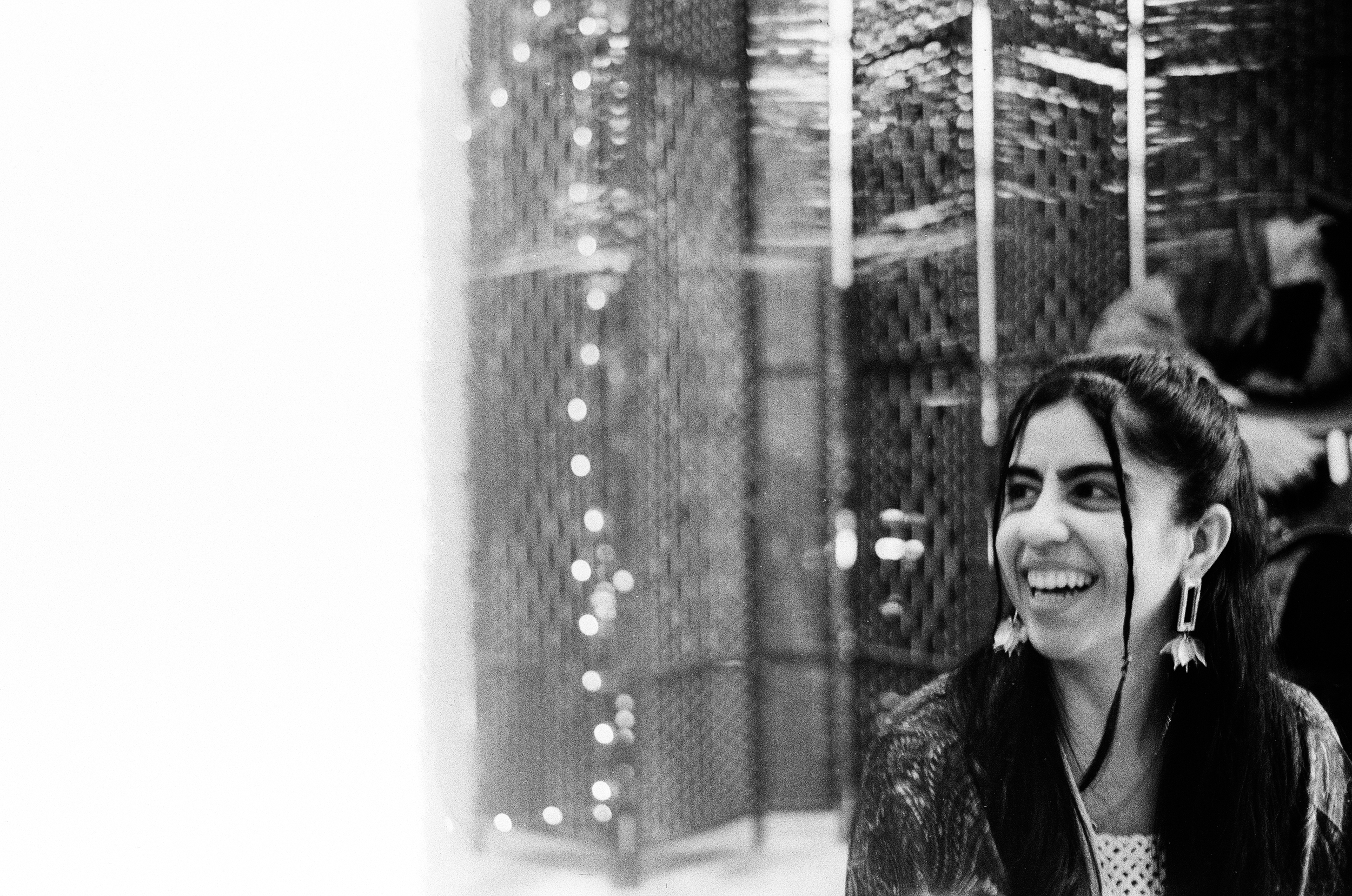 Sanam Panjwani, a South Asian somatic coach in Toronto, Canada, smiling warmly while seated on a couch, offering nervous system regulation and somatic tools for mid-level corporate professionals facing burnout.