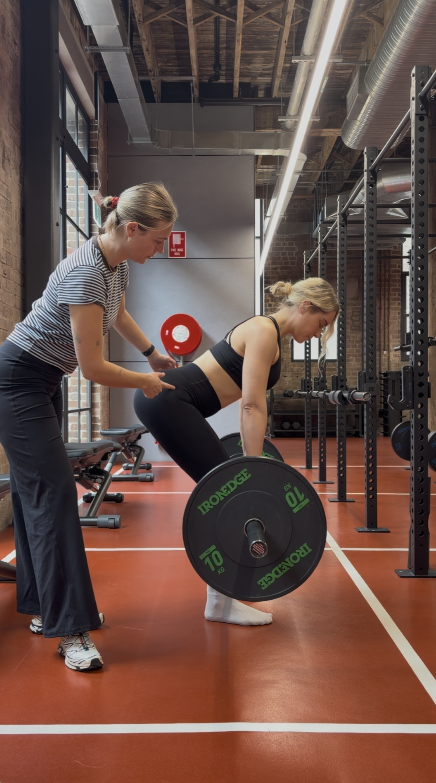 physio correcting patient technique in gym