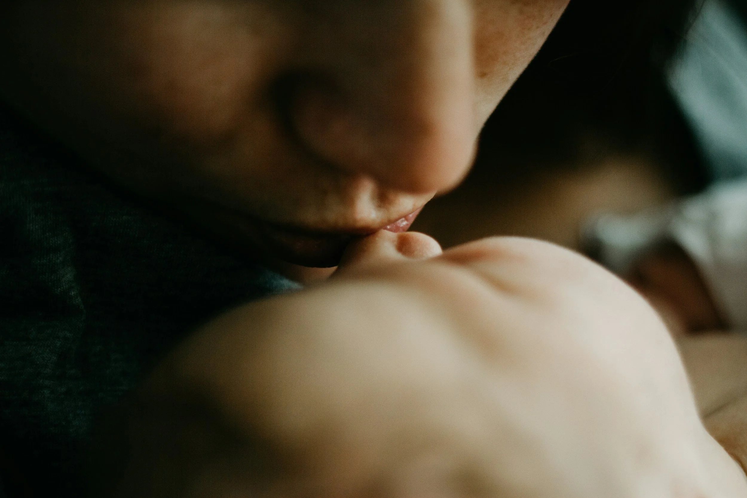 Close-up of a young child's face, focusing on the nose and mouth, with the child resting their finger near their lips.