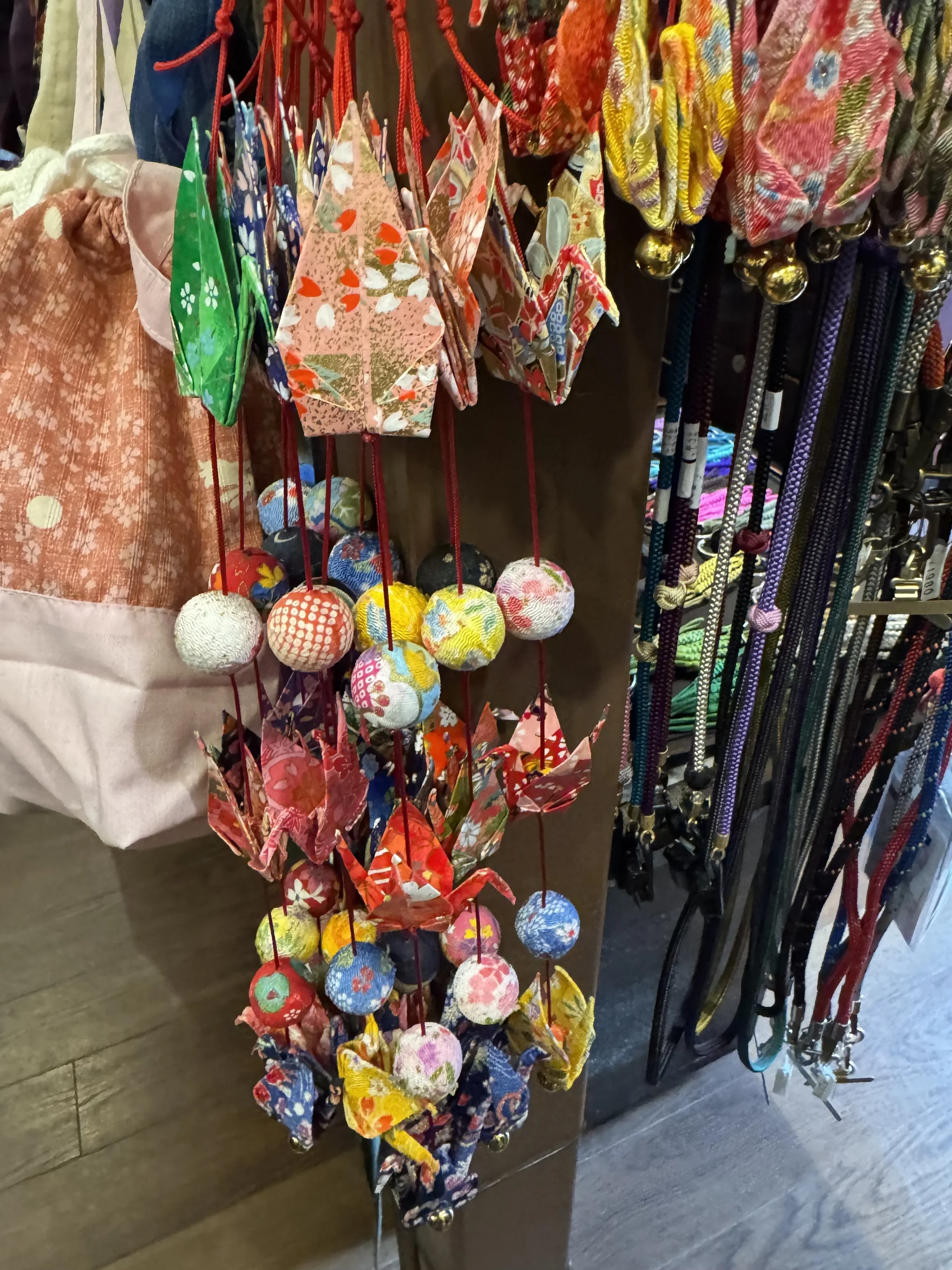 Paper cranes hang from a strand with crepe fabric balls.