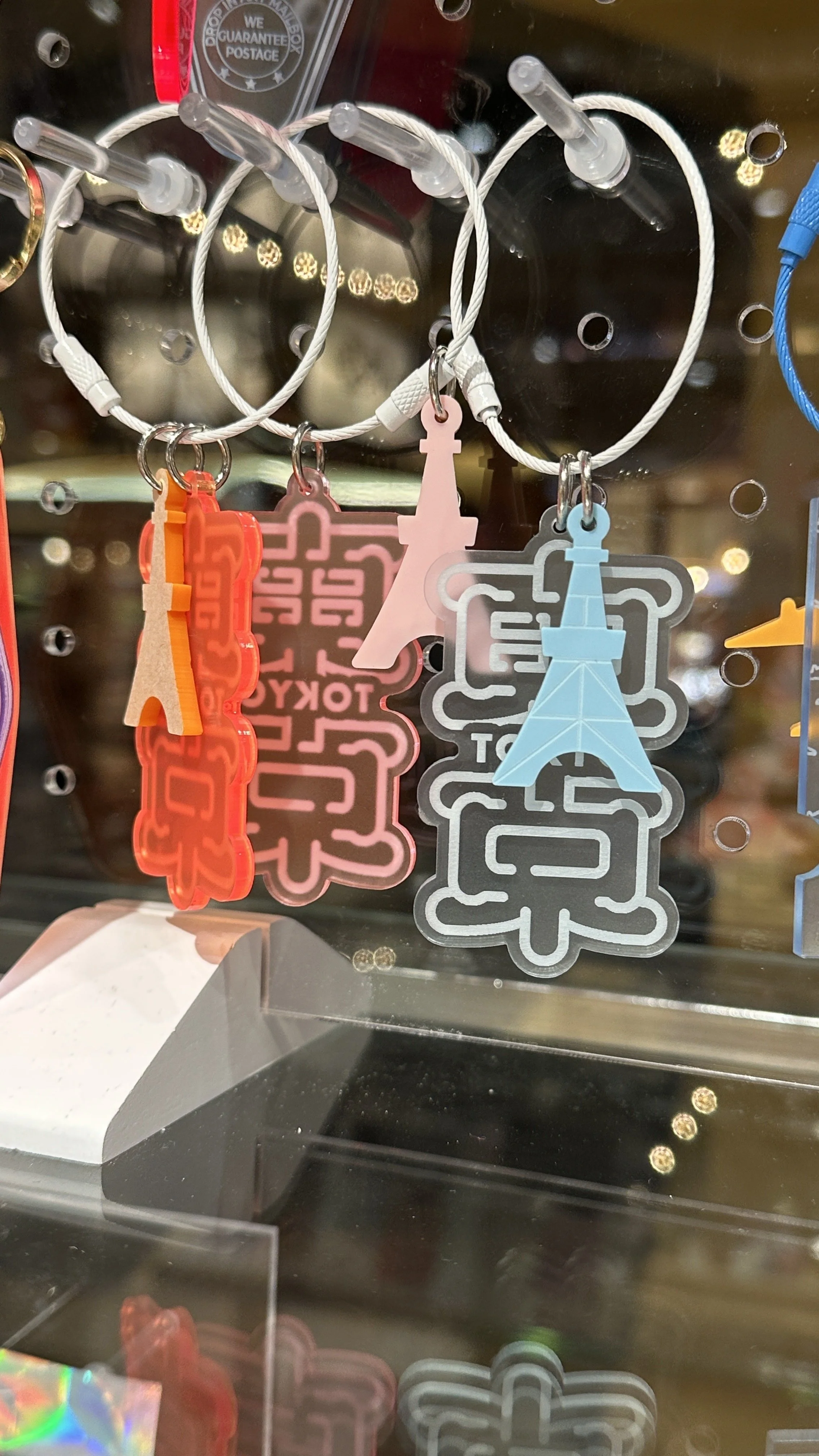Acrylic keychains that say Tokyo.
