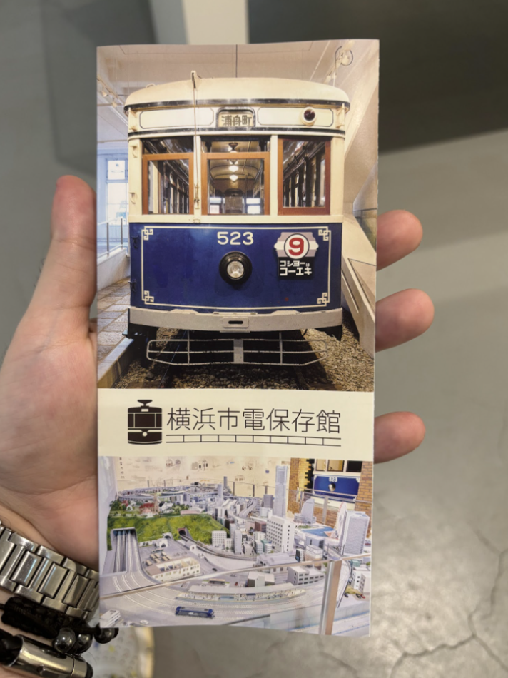 Train museum ticket is held in the hand of a visitor in Japan.