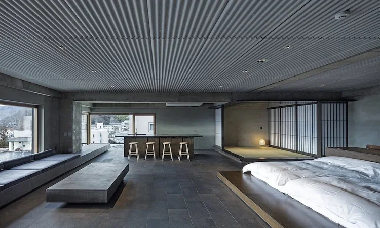 A modern concrete and wood hotel interior in Matsumoto, Japan.