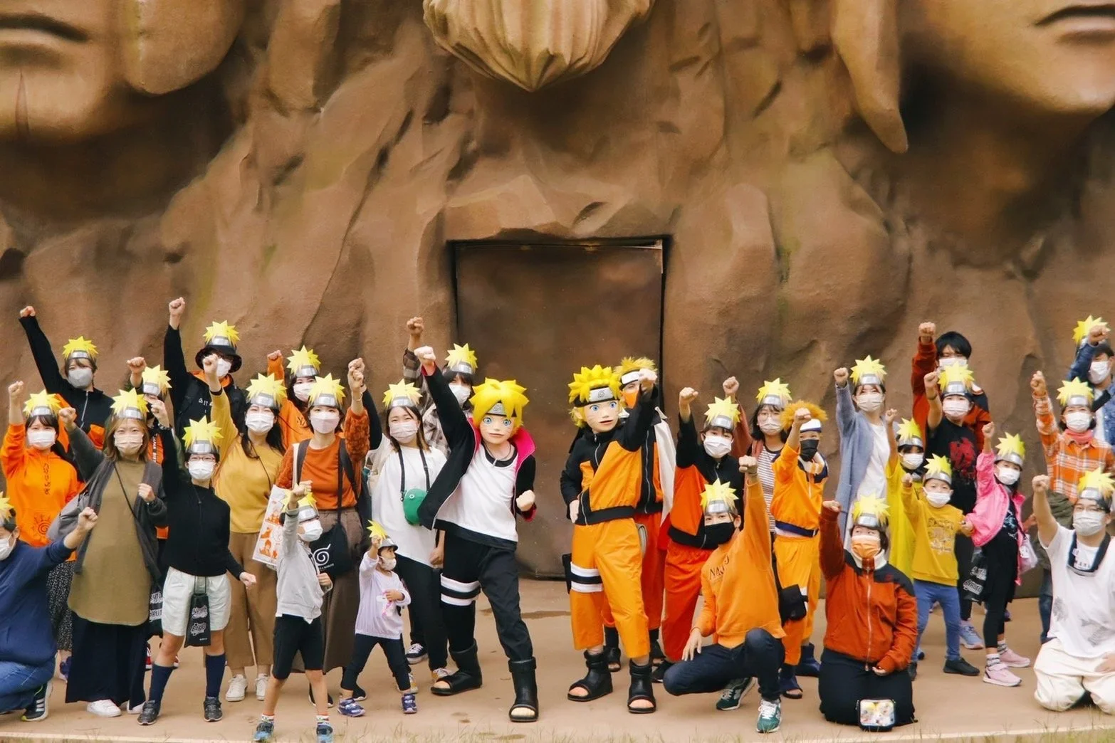 A group in orange jumpsuits and other athletic apparel dressed as naruto characters poses.