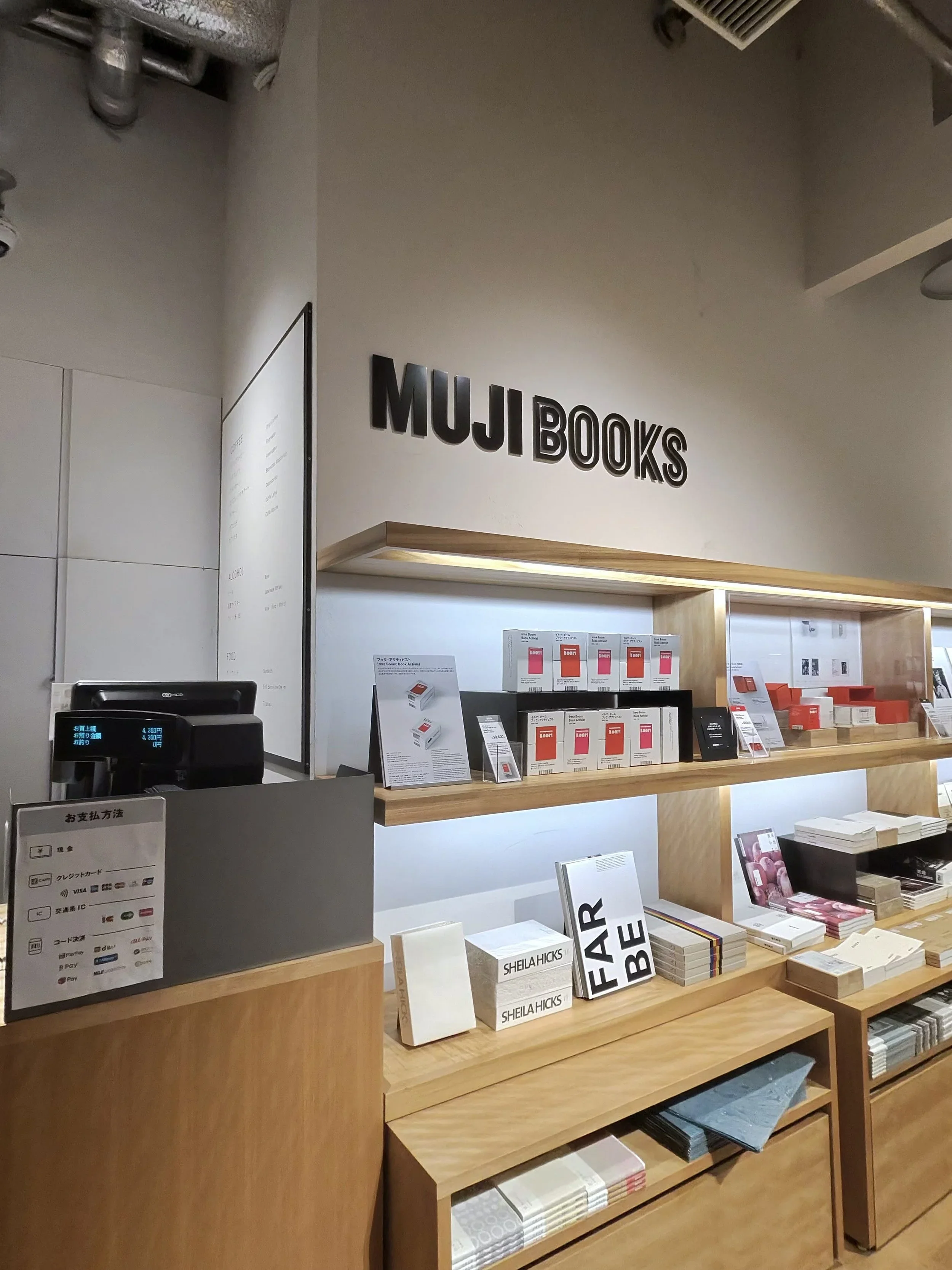Muji books store with blonde wood shelving and books stacked with a lot of white space.