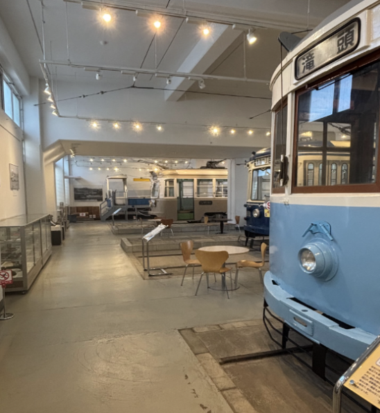 Interior of the Yokohama Tram Museum with blue and white retired train car on the right side.