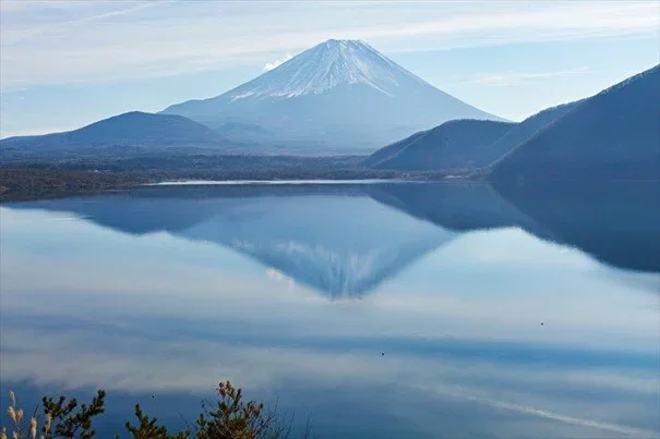 Mount Fuji reflected in a lake scene.