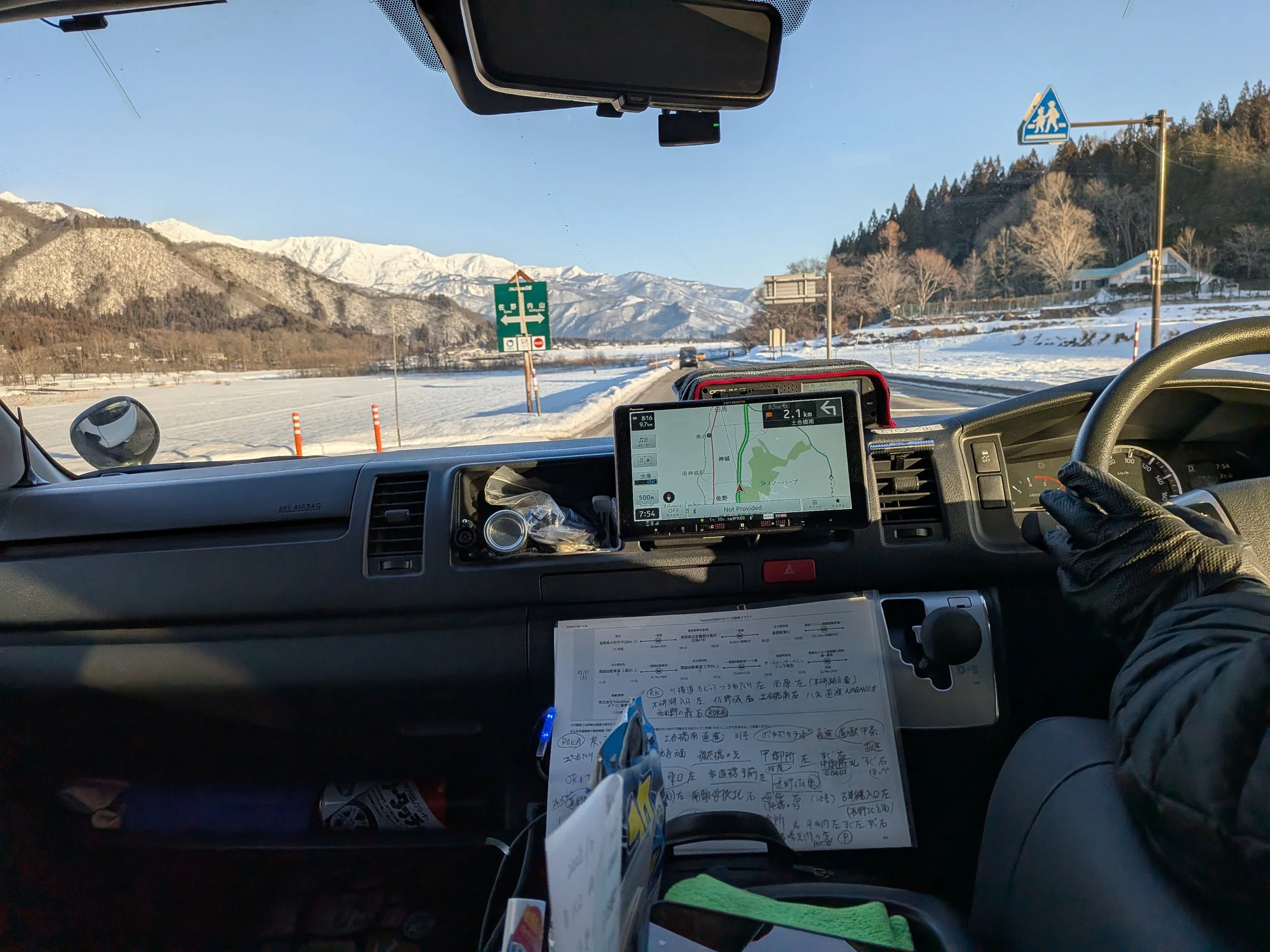 A TokudAw diver transporting skiers and snowboarders through a snowy Japanese road in the Japanese Alps of Hakuba in winter so they can catch some fresh japow.