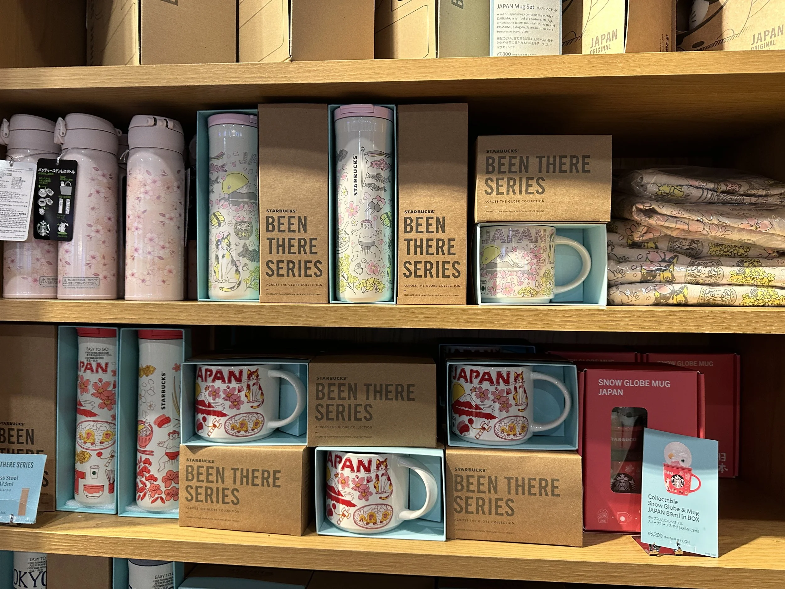 The Been There Series of mugs from Starbucks featuring the red style always available and a seasonal pink style available only in early Spring. The mugs are displayed at Starbucks.
