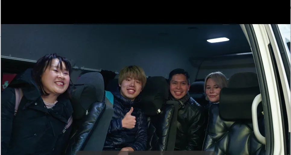 4 guests pose in the TokudAw van, taken from the open door.