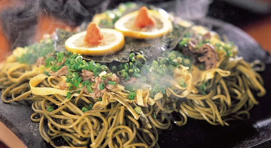 A green tea infused soba with lemon slices on top.