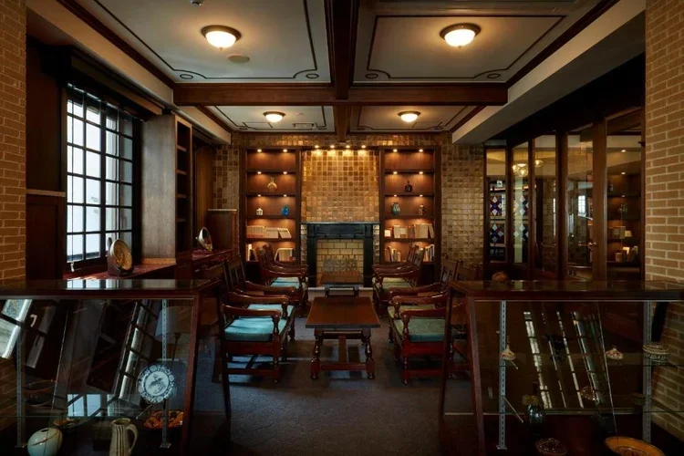 Vintage style hotel lobby with large wooden features of dark warm wood, similar to a smoking room appearance.