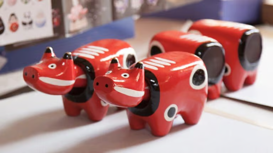 4 red, white, and black painted cow figurines.