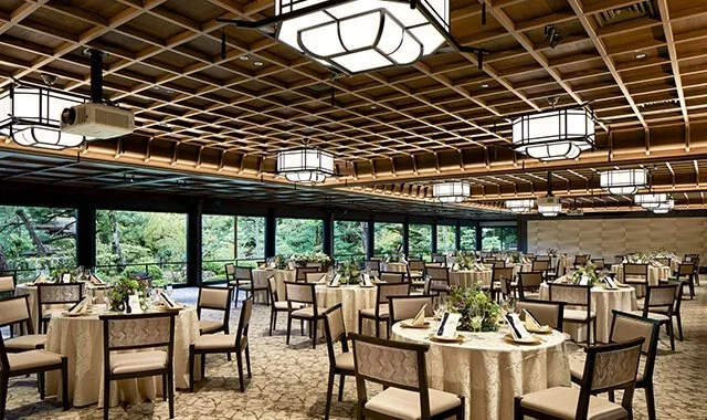 A hotel ball room mixes traditional Japanese decor with modern Japan with bambo touches, low ceilings and neutral colors.