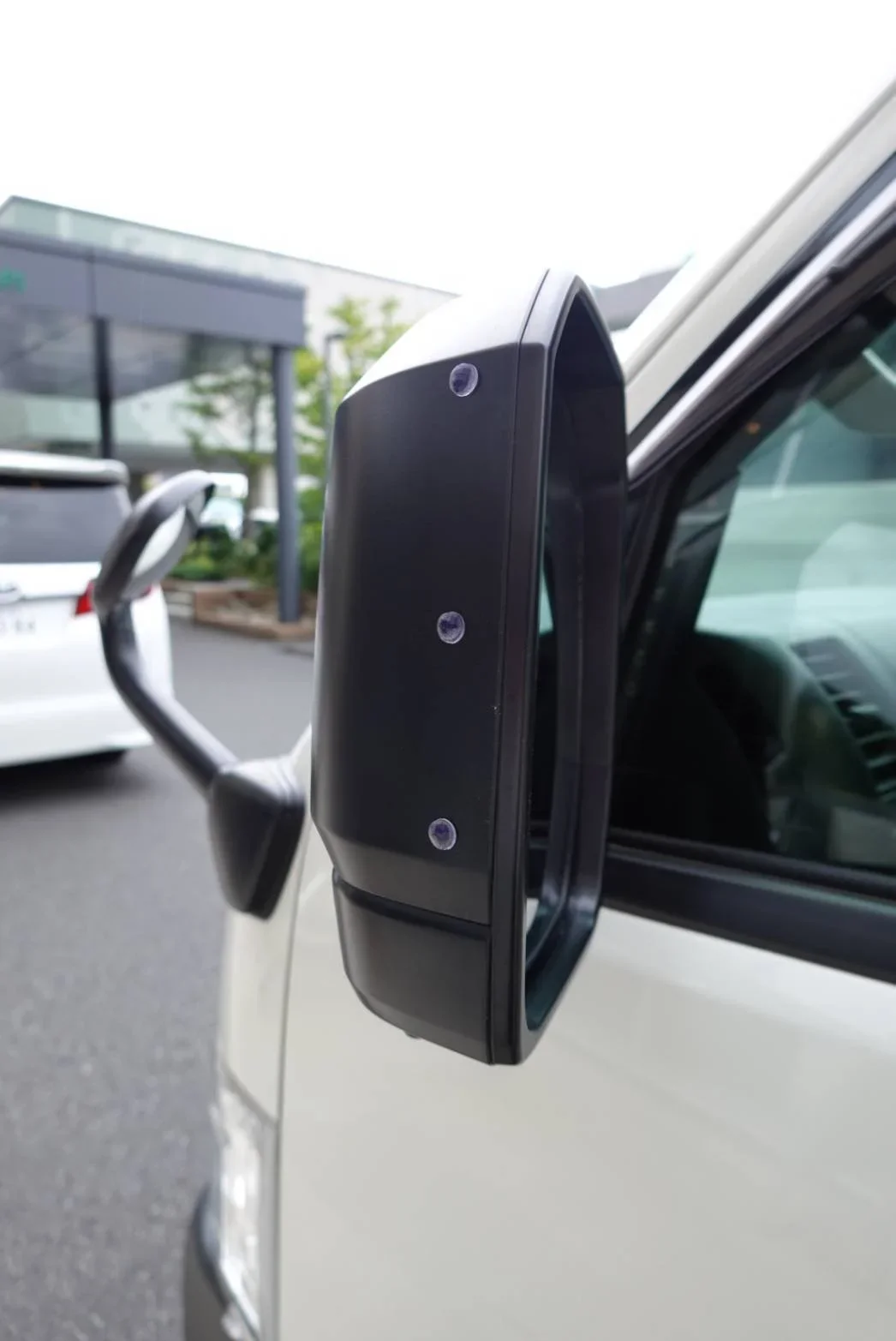 Up close image of the mirror of a TokudAw fleet vehicle with special equipment attached