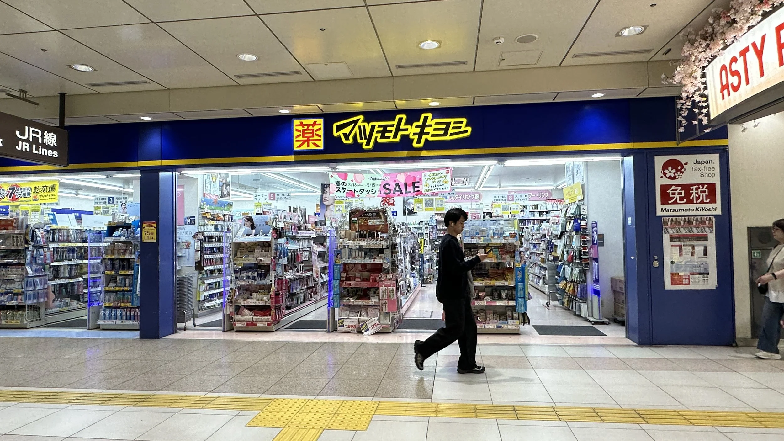 Image from outside a Japanese pharmacy store looking towards the aisles of the skincare products.