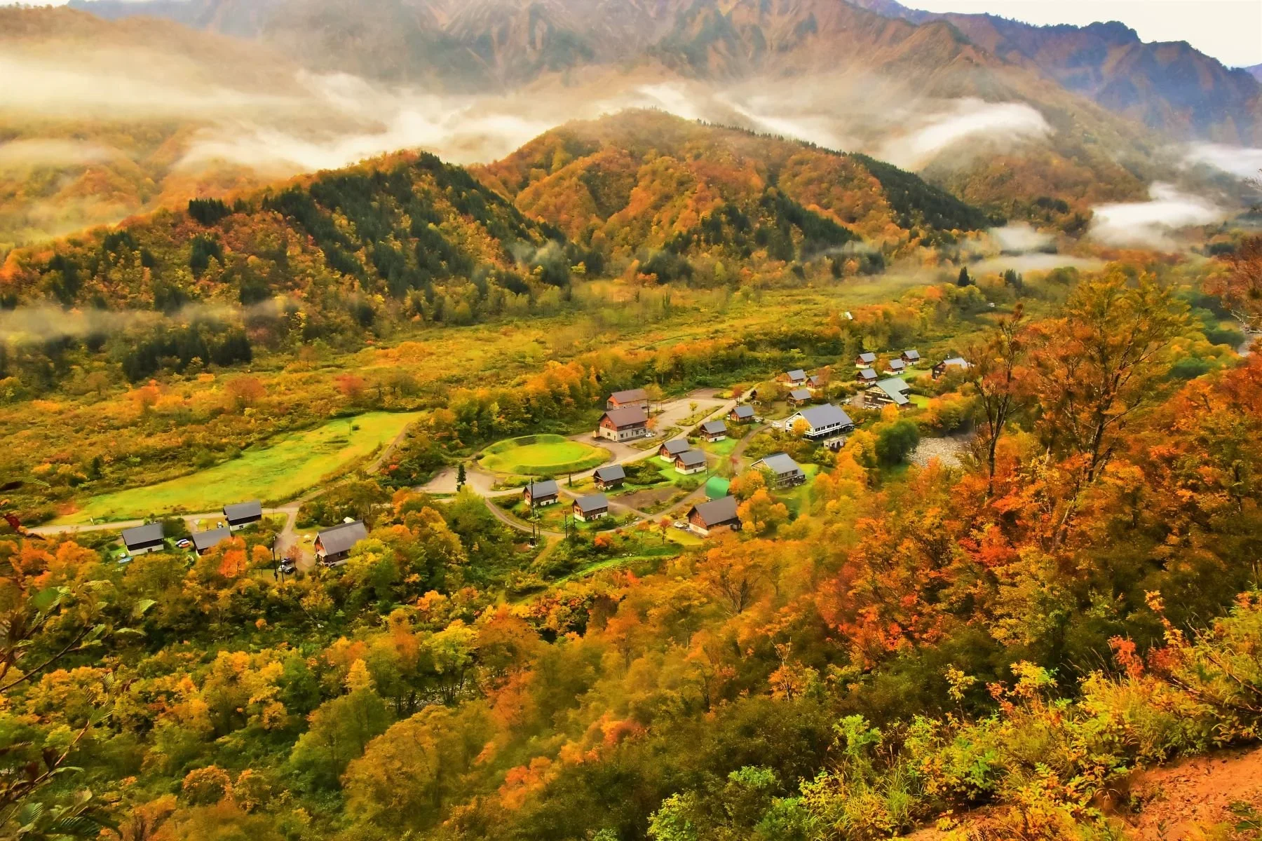 Fall mountain scene overlooking a small Japanese village in Tohoku, Japan.