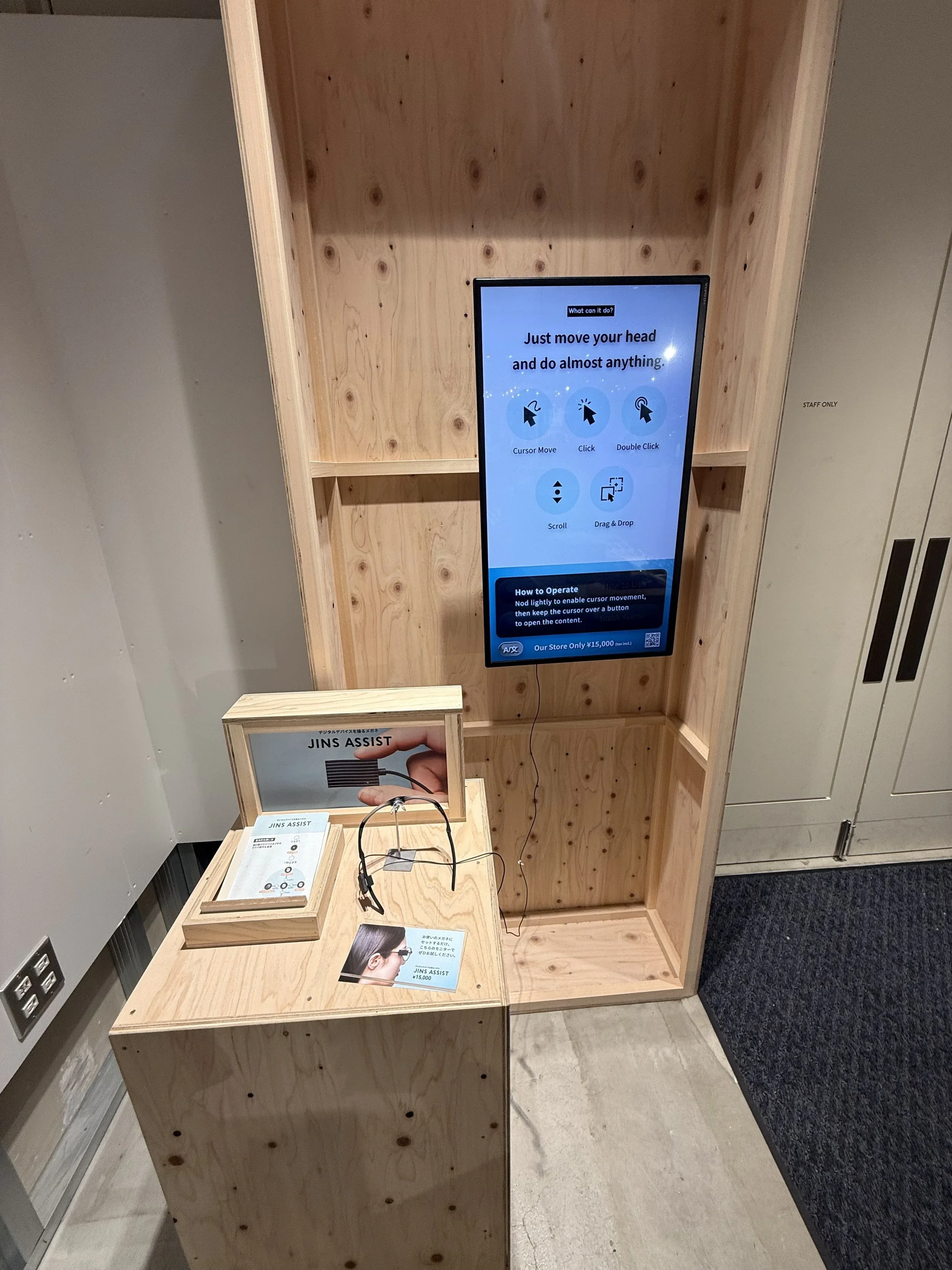 An interactive TV screen that asks you to move your head to do anything at the Jins store mounted on a plywood display.