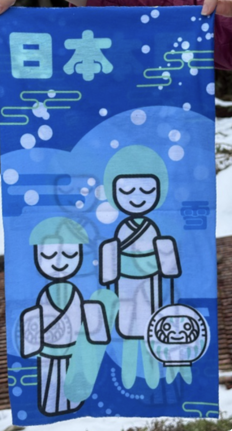 Japanese snows sports family made up of a father kokeshi doll snowbaording, the mother kokeshi doll skiing and the child daruma doll snowboarding.